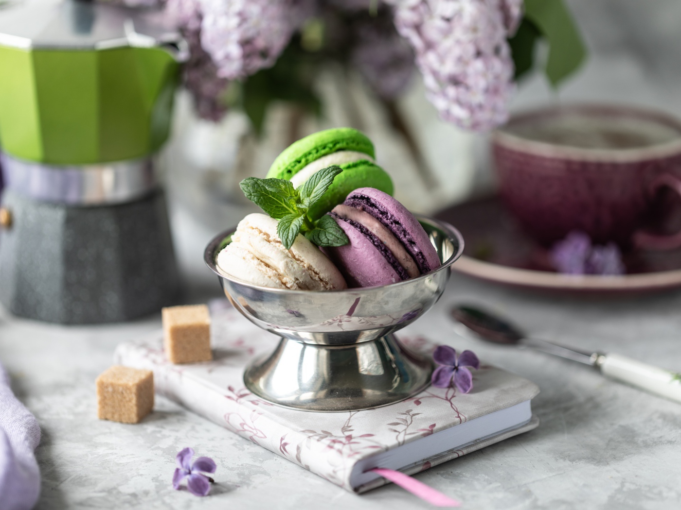 Три печенья макарун на столе с блокнотом