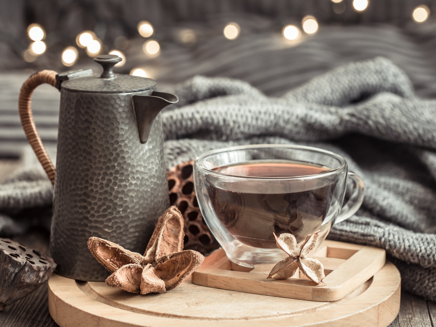 Чашка чая на столе с чайником и теплым пледом