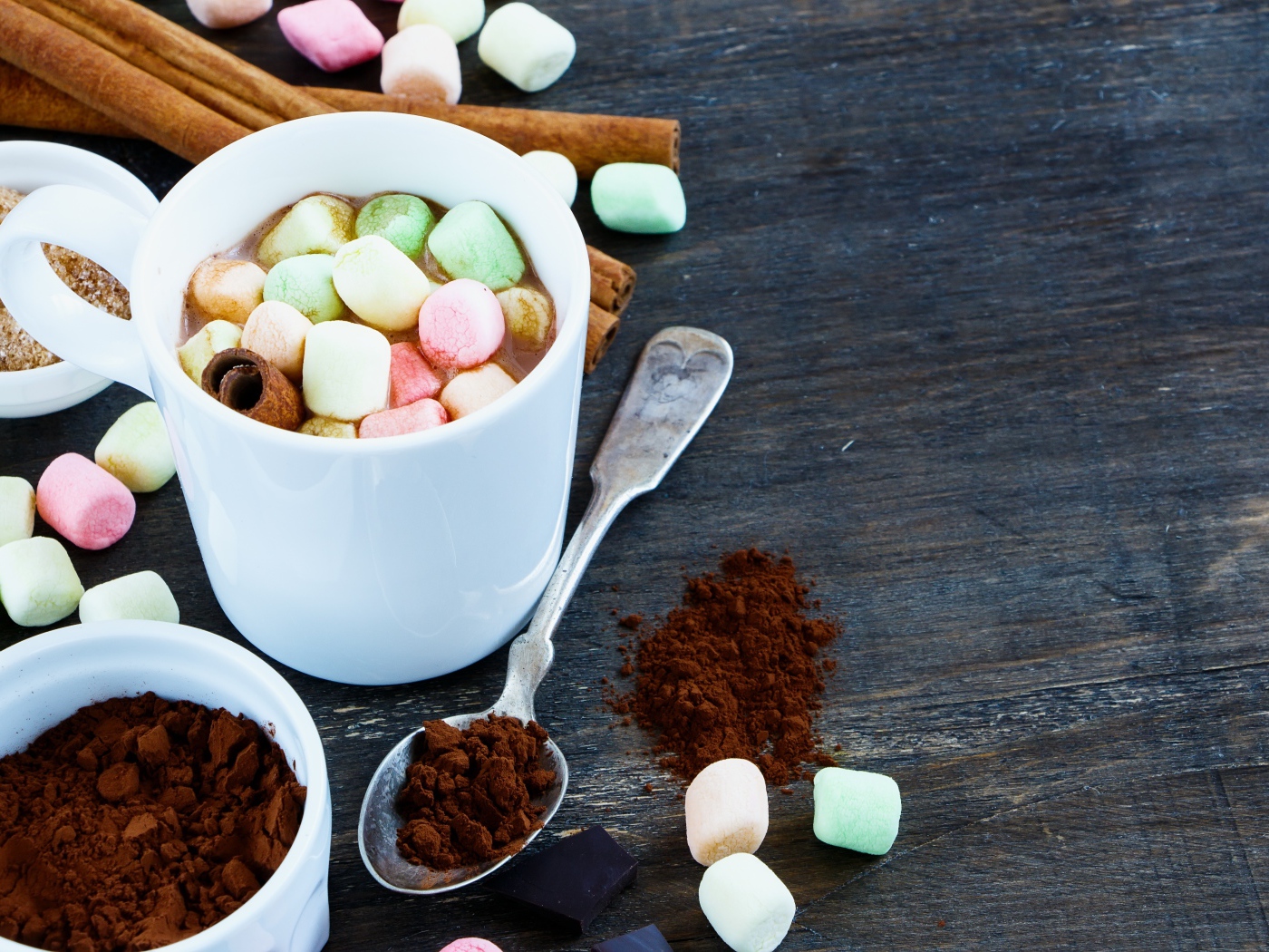 Кофе с маршмеллоу на столе с корицей и сахаром