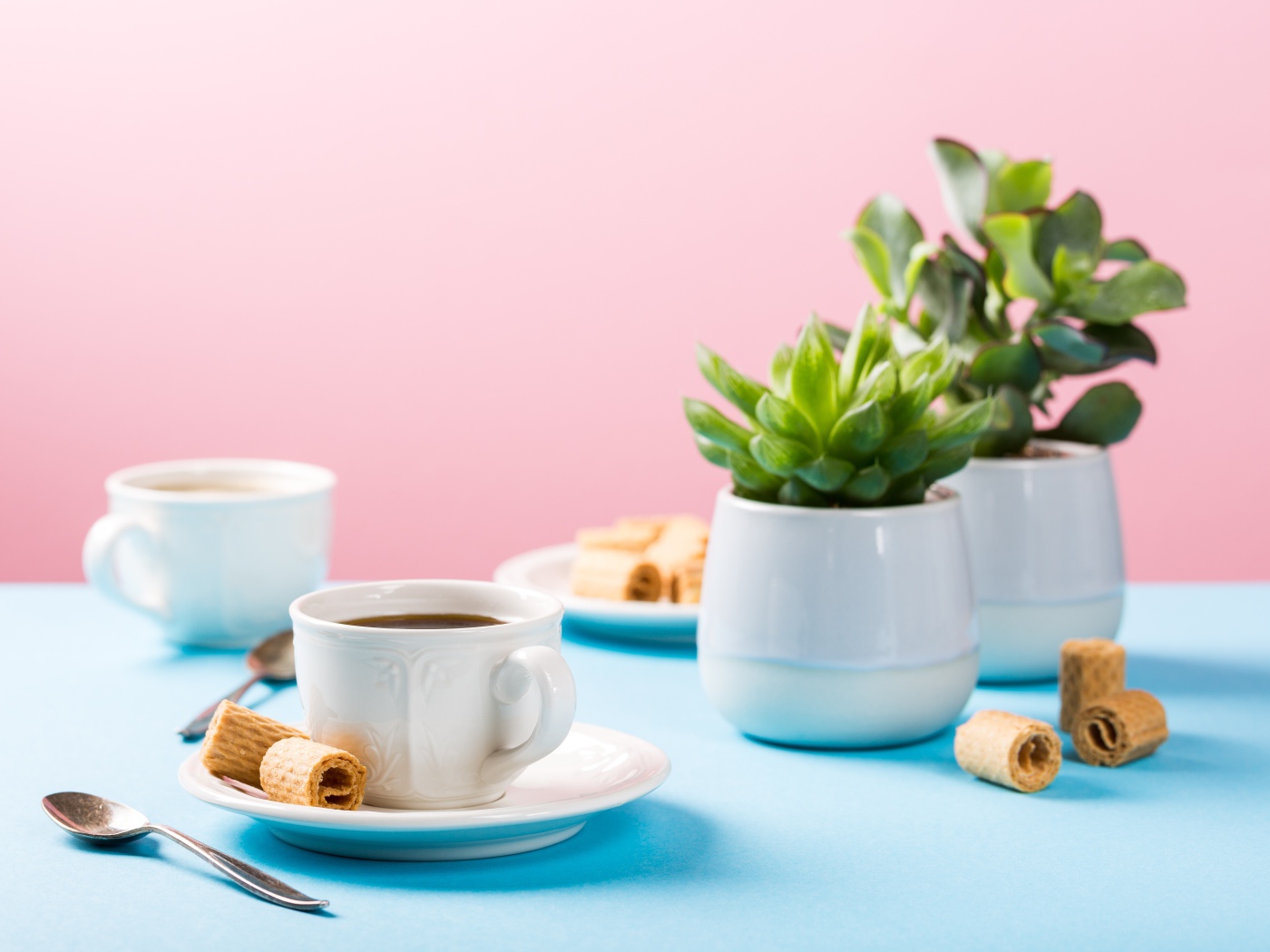 Чашка кофе на блюдце с вафлями на столе с цветами