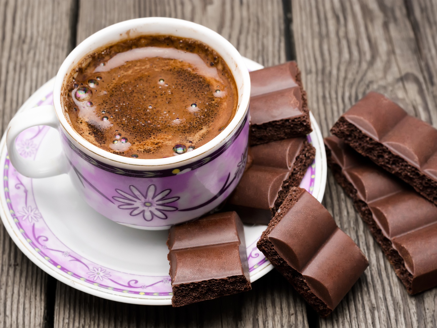 Чашка кофе на столе с кусочками шоколада