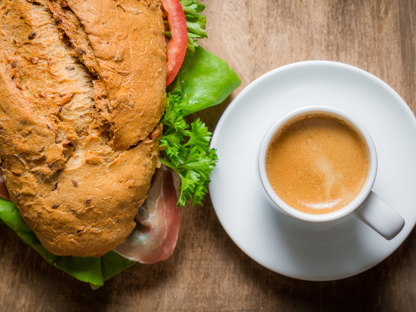 Чашка кофе с бутербродом на столе к завтраку 