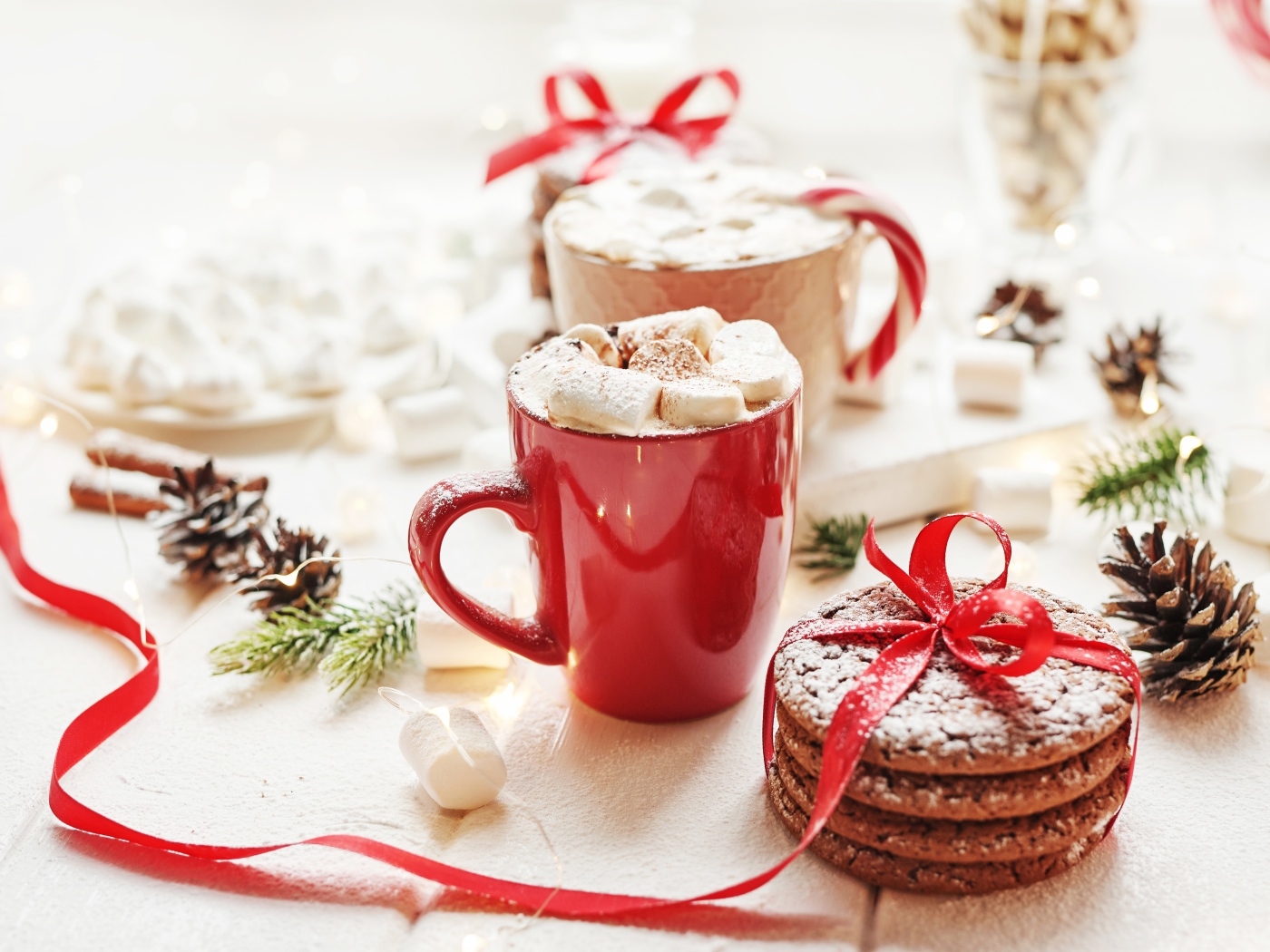 Чашки напитка с маршмеллоу на столе с печеньем