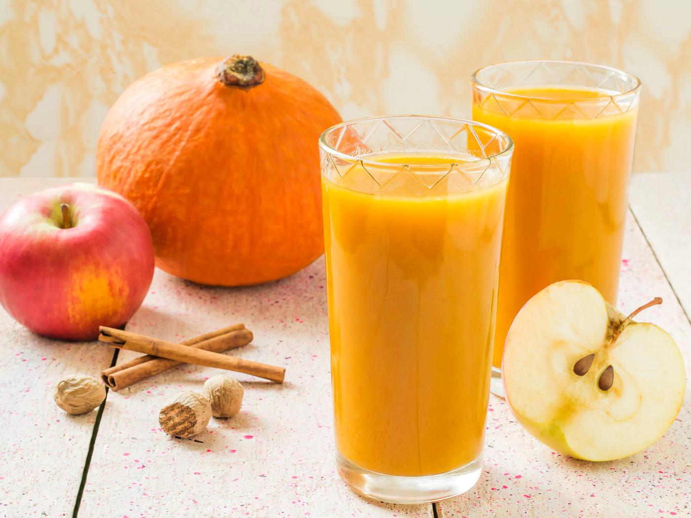 Свежевыжатый сок в стаканах на столе с фруктами