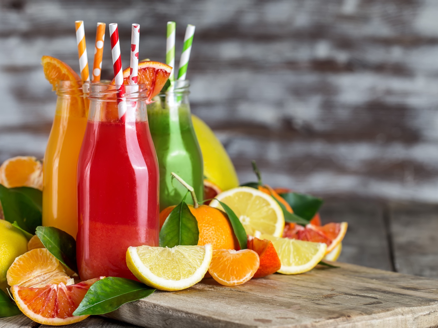 Фруктовое смузи на столе в бутылках с трубочками