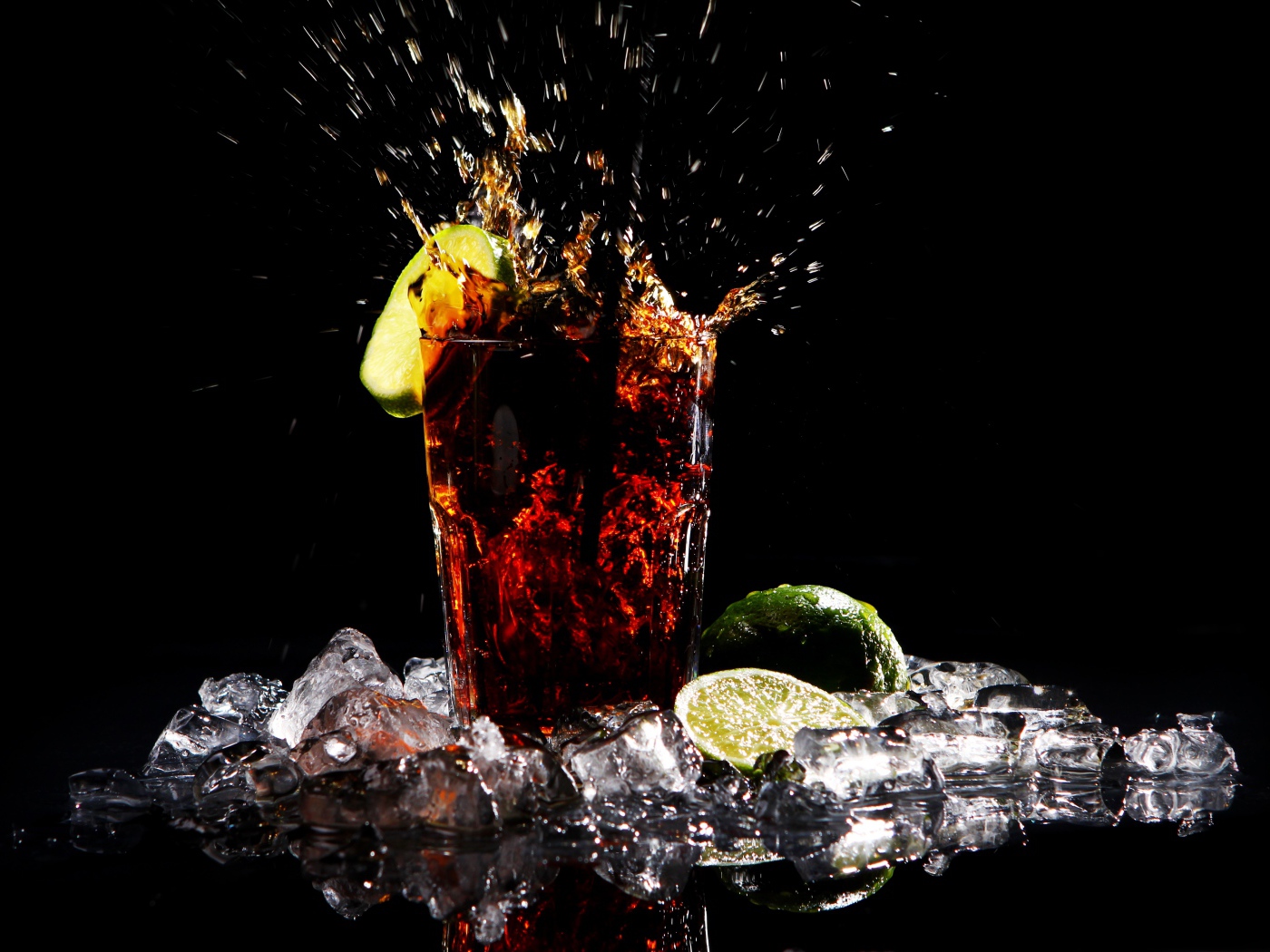 Стакан кока колы на черном фоне со льдом