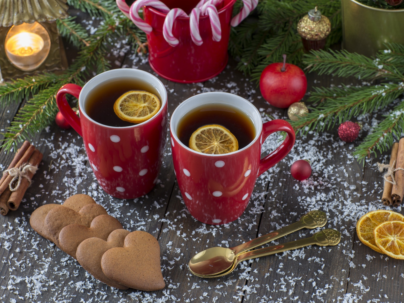 Две чашки чая с лимоном на столе с печеньем и еловыми ветками