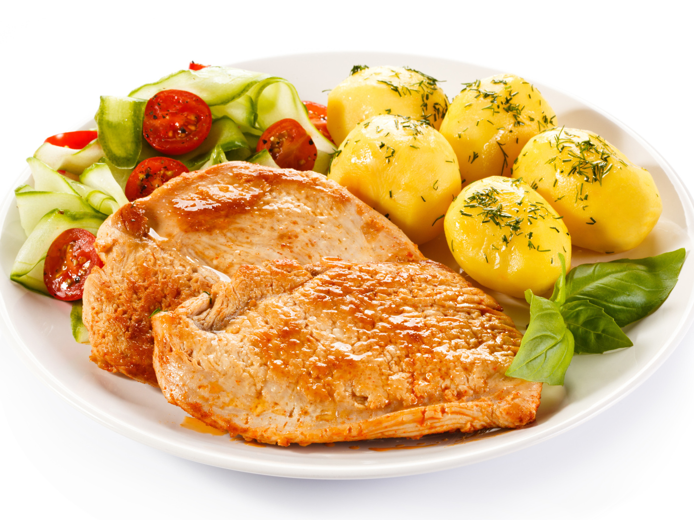 Кусок сочного куриного мяса на тарелке с картофелем и салатом