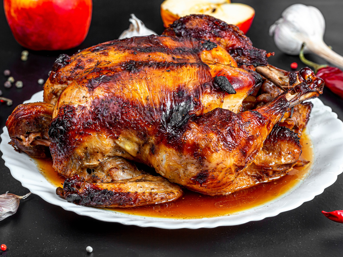 Вкусная запеченная курица на белой тарелке на столе с овощами