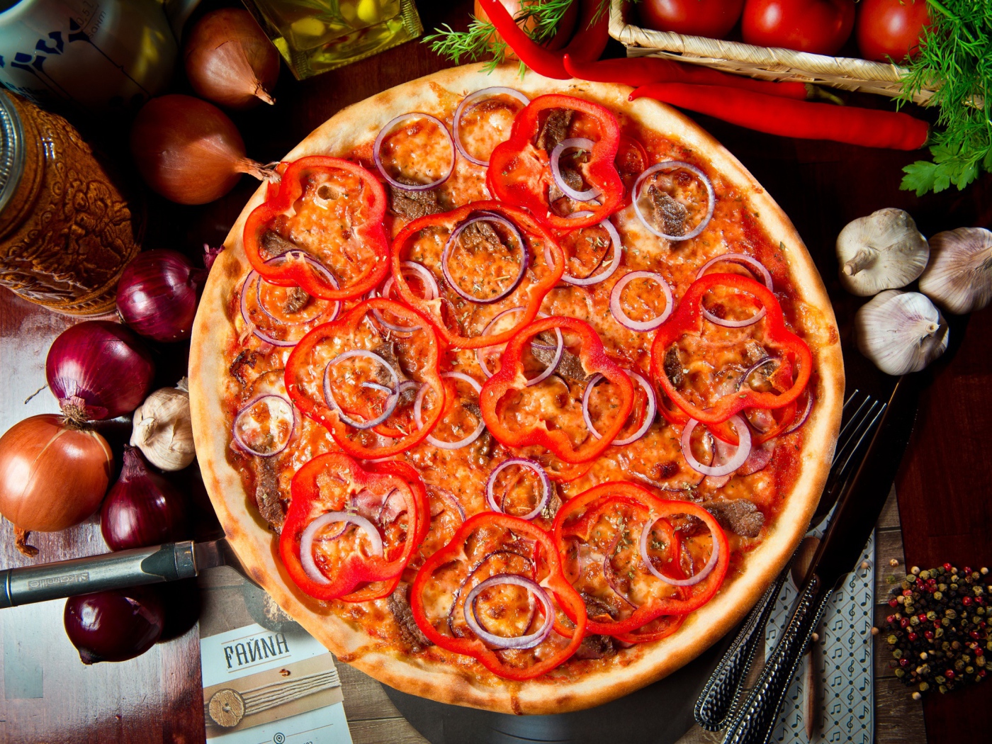 Большая пицца с мясом, луком и болгарским перцем на столе 