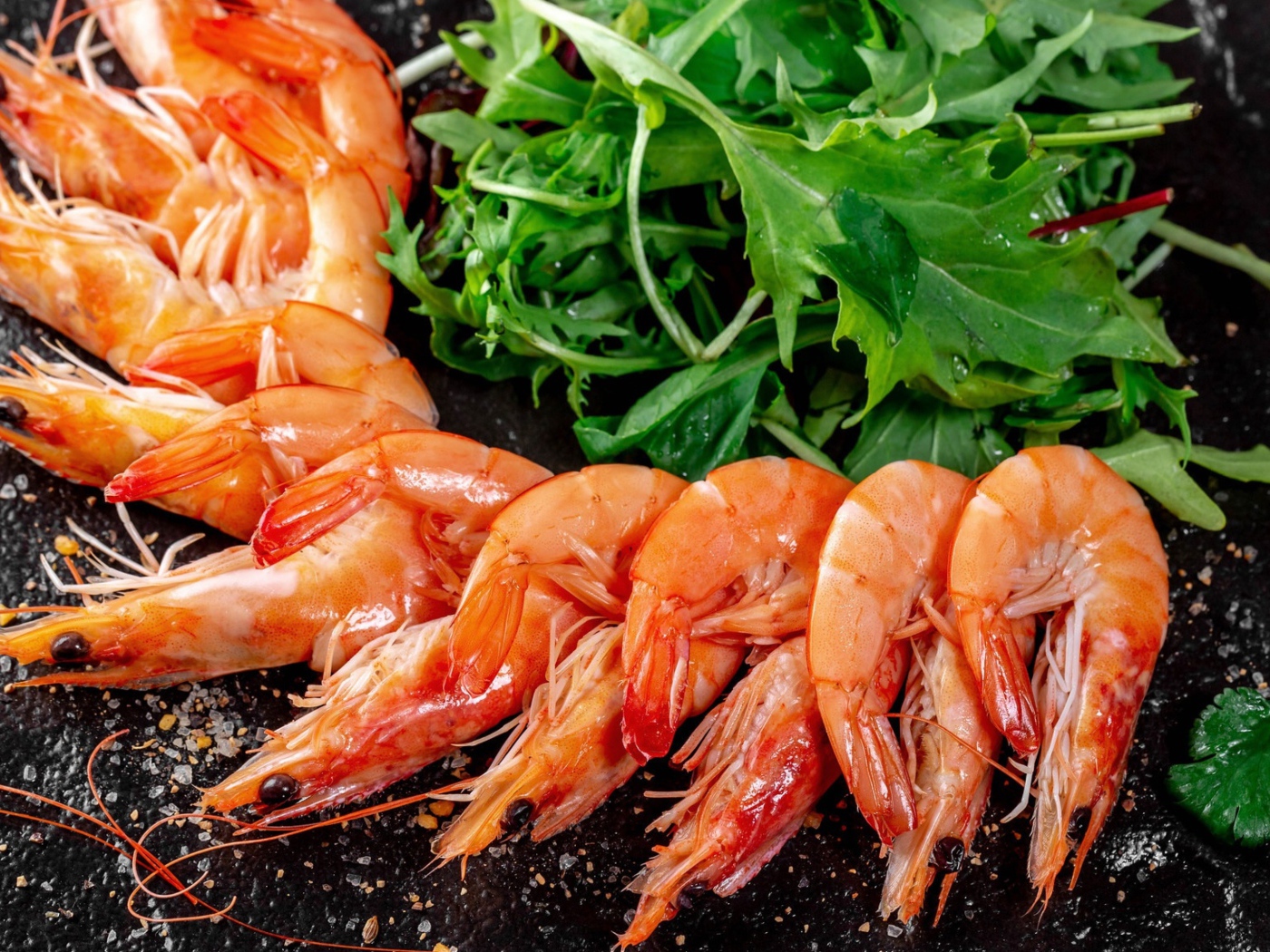 Вареные креветки на столе с зеленью рукколы