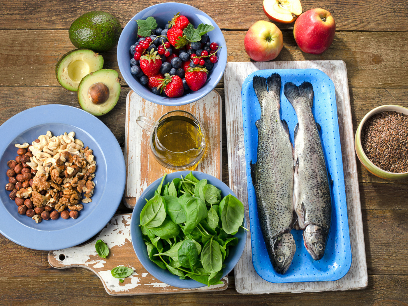 Fresh fish on a table with nuts, basil and berries