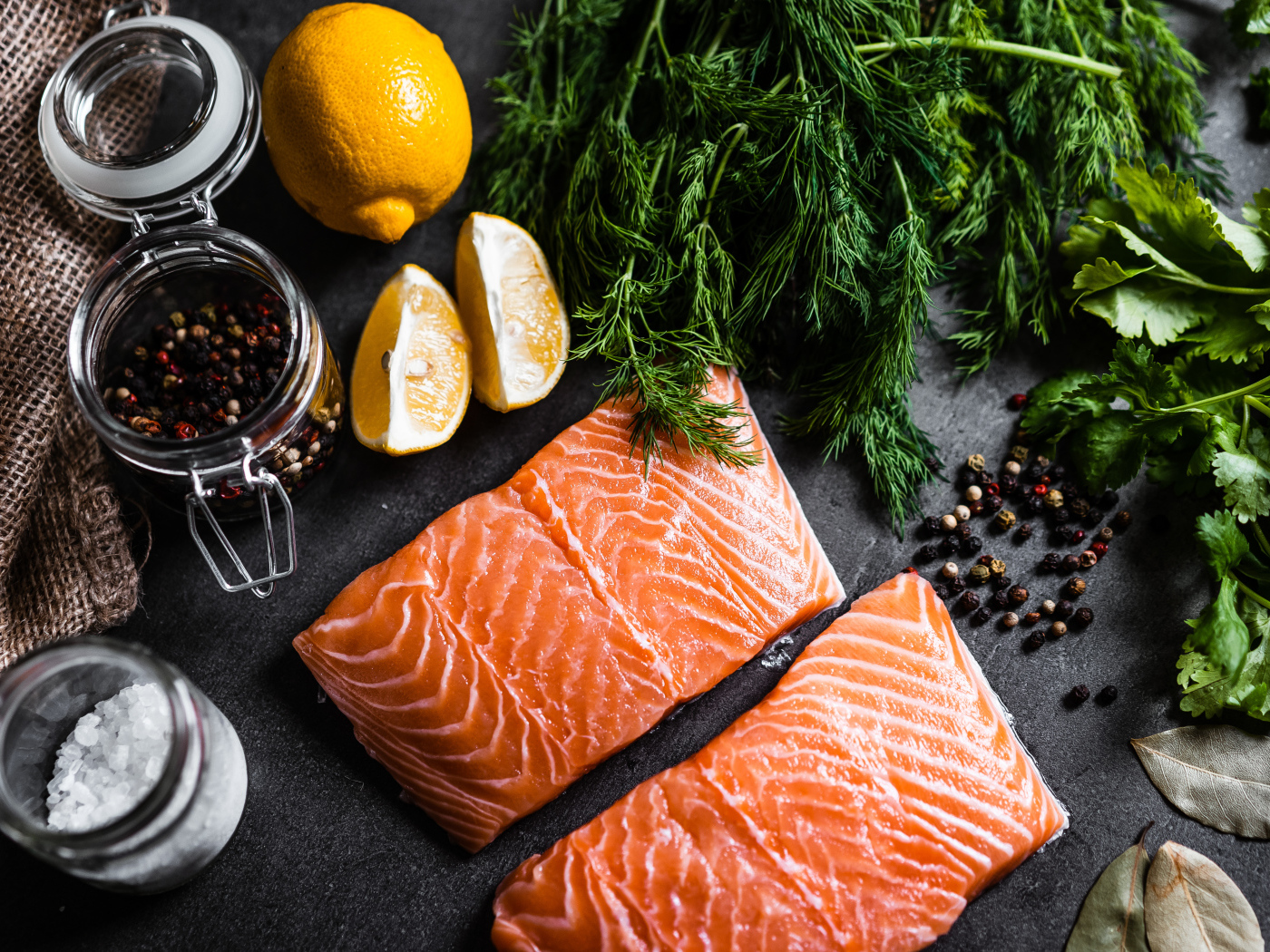 Pieces of red fish on a table with herbs and spices