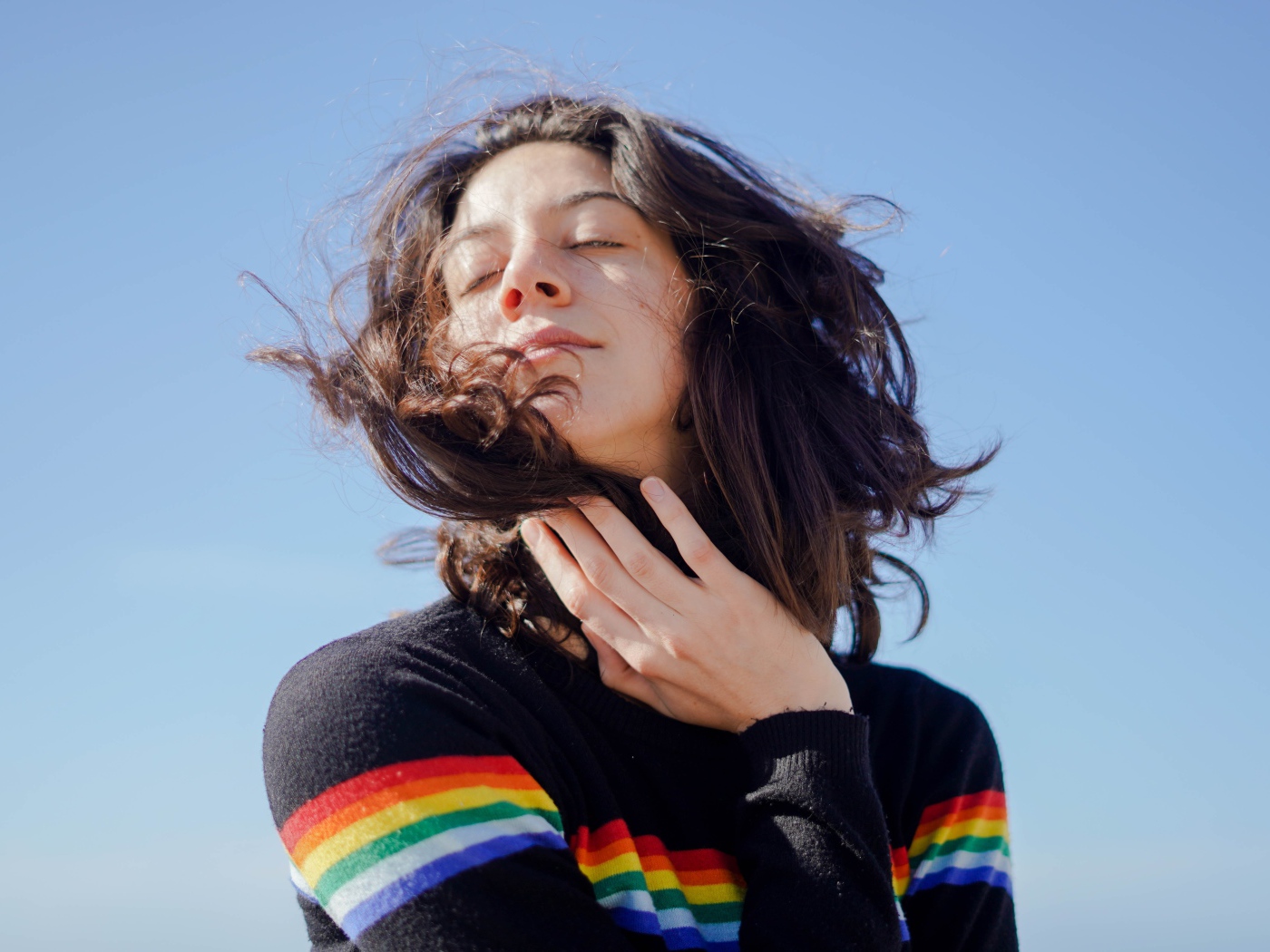 Молодая девушка греет лицо на солнце