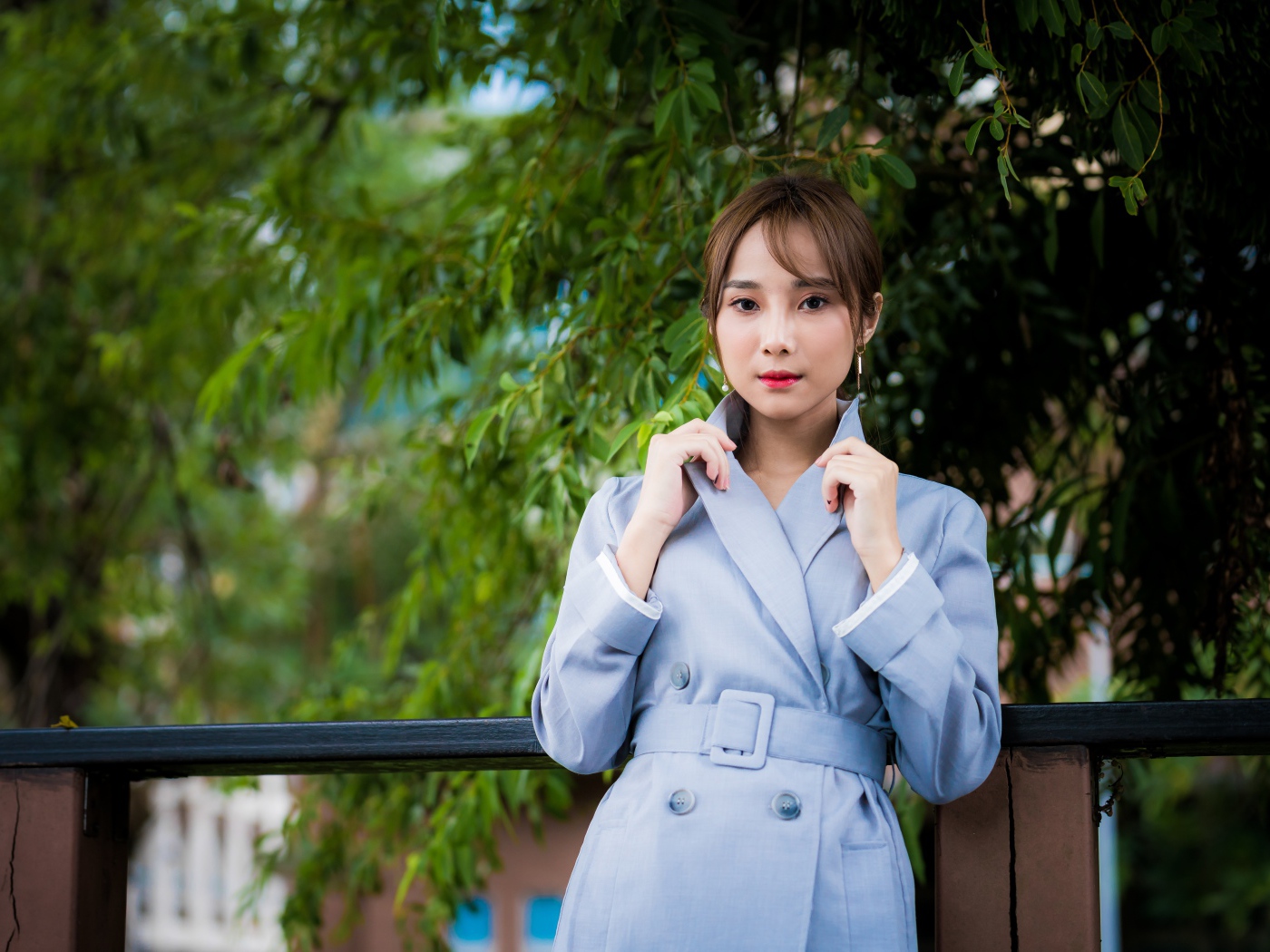 Девушка азиатка в голубом пальто в парке