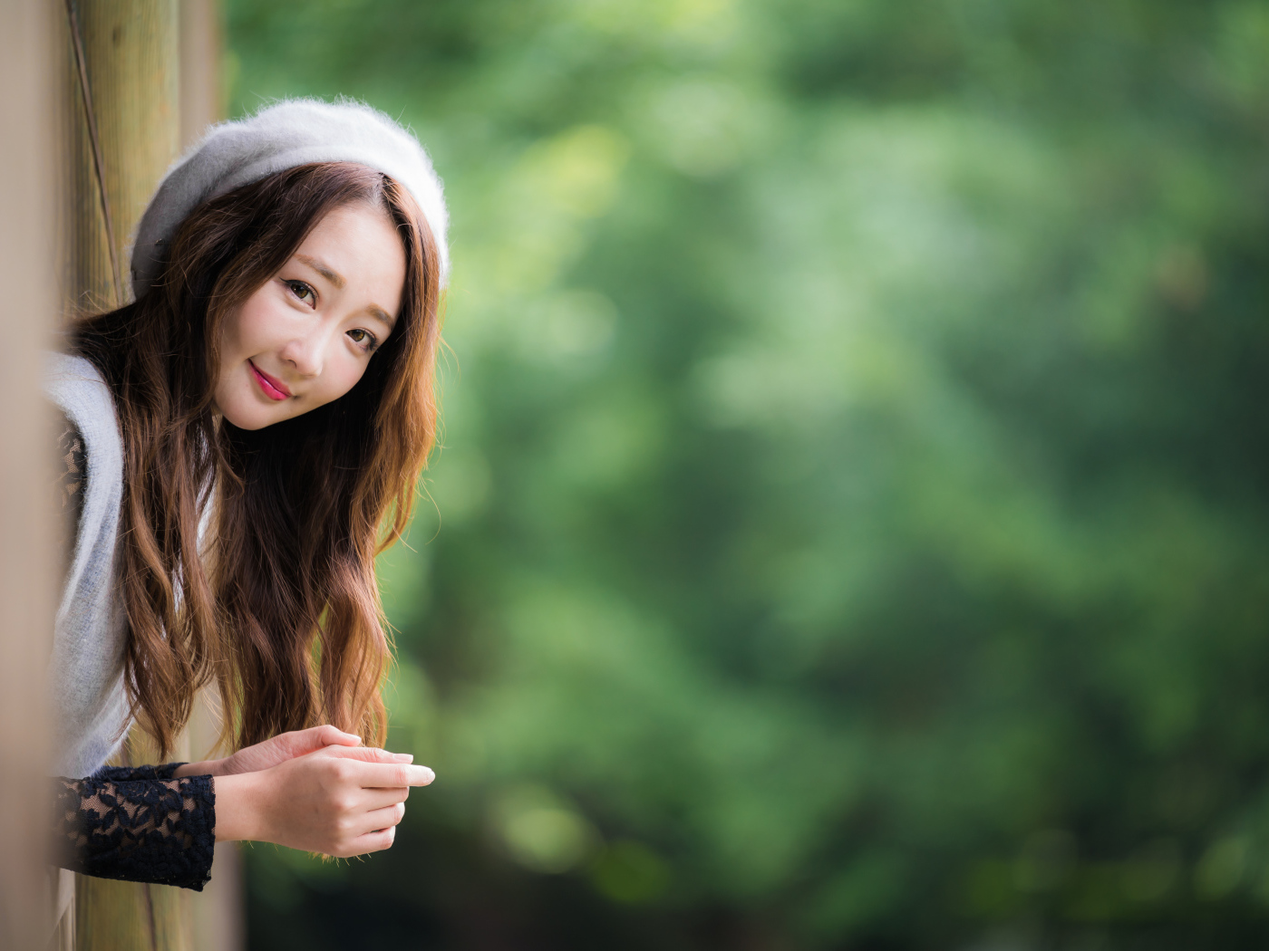 Азиатка в берете выглядывает из окна