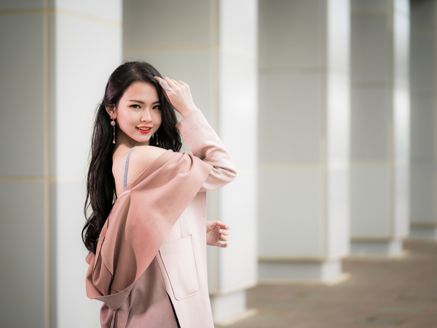 Красивая девушка азиатка с длинными волосами в розовом пальто 