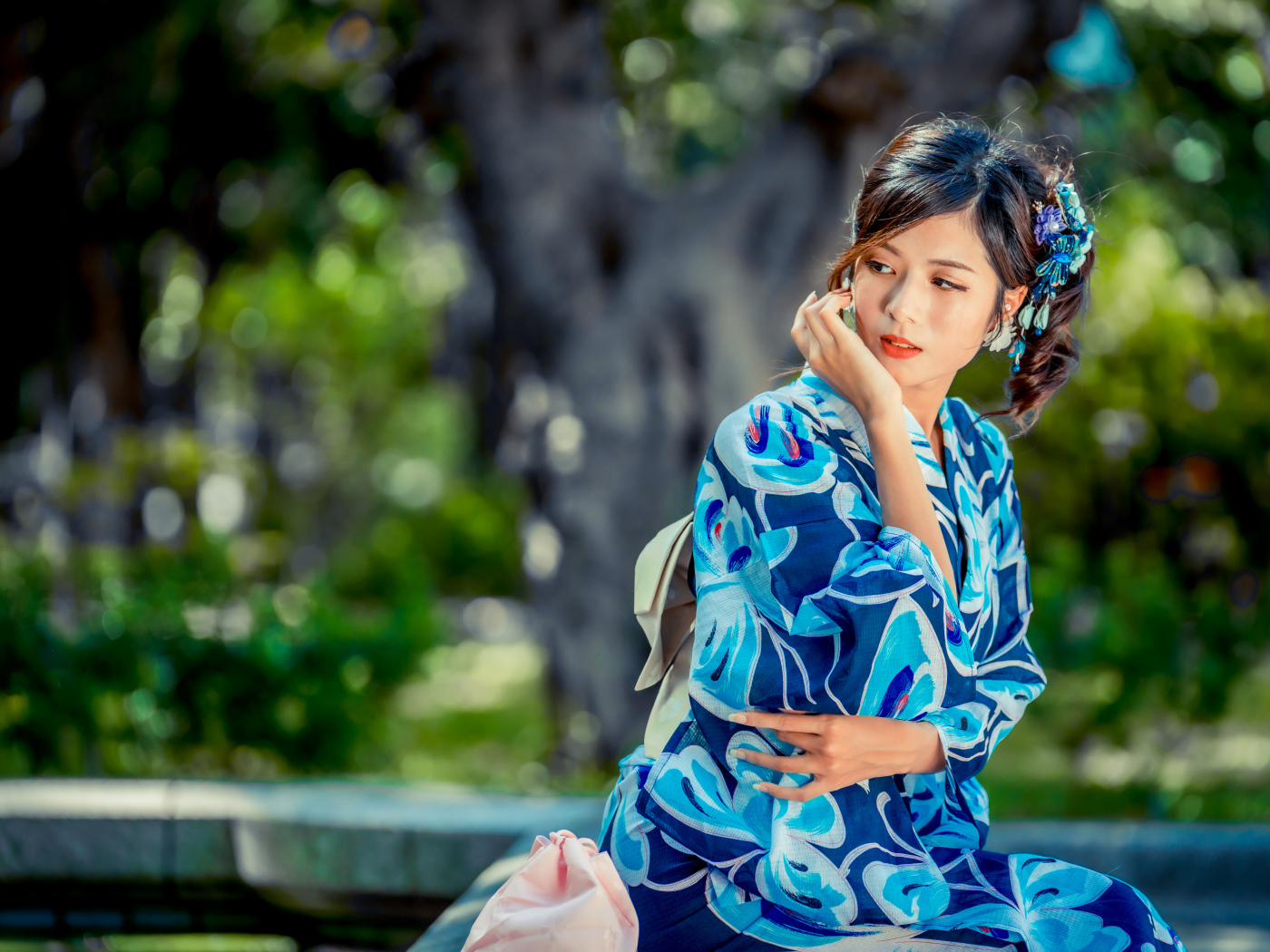 Красивая азиатка в разноцветном кимоно в парке