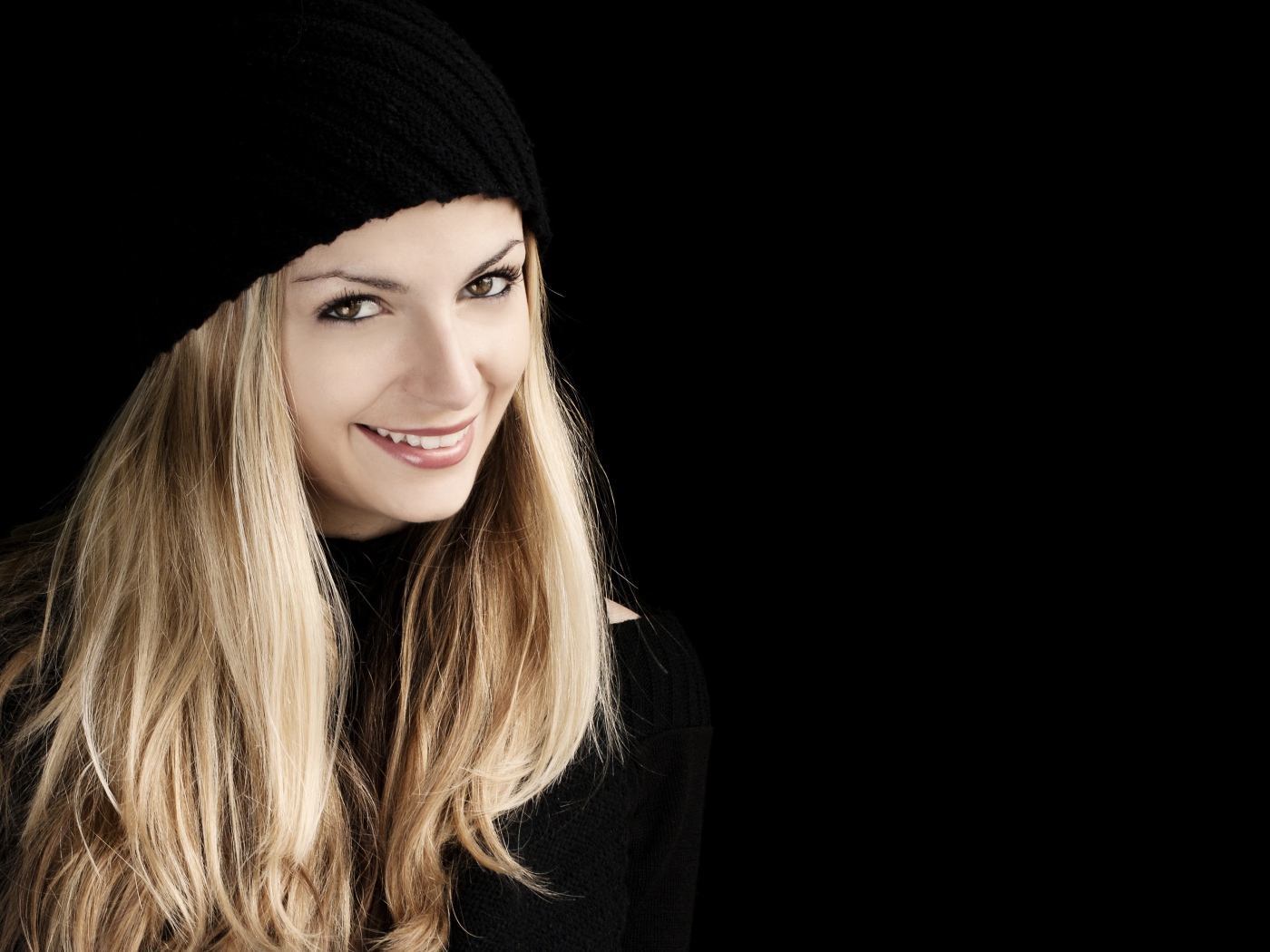 Красивая блондинка в шапке на черном фоне