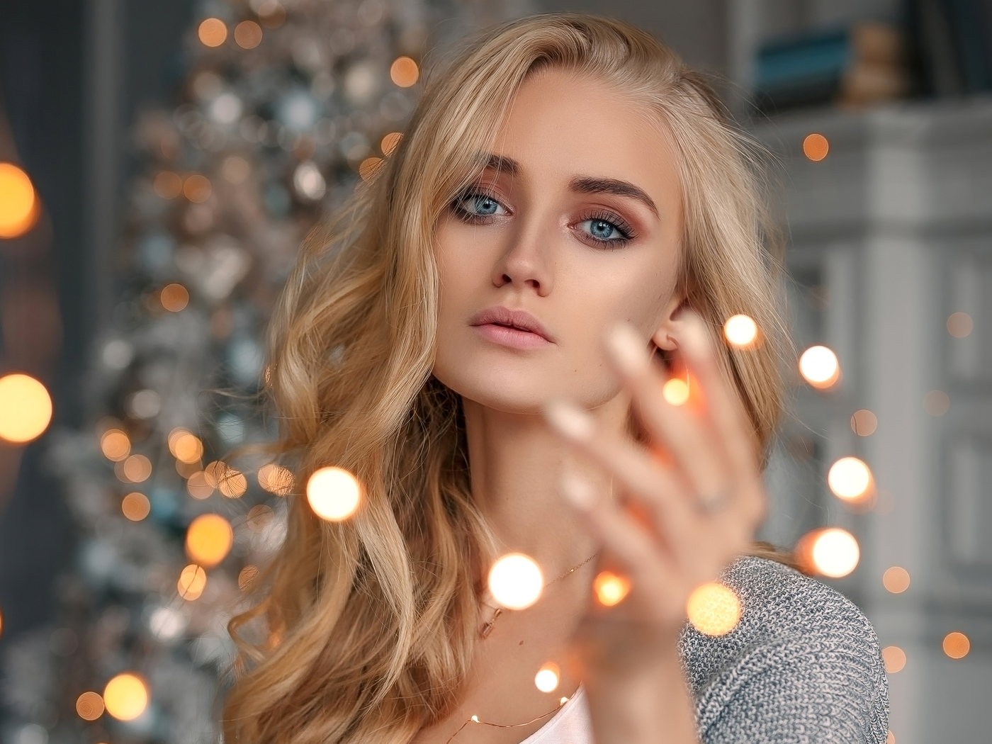 Красивая голубоглазая блондинка с гирляндой в руке