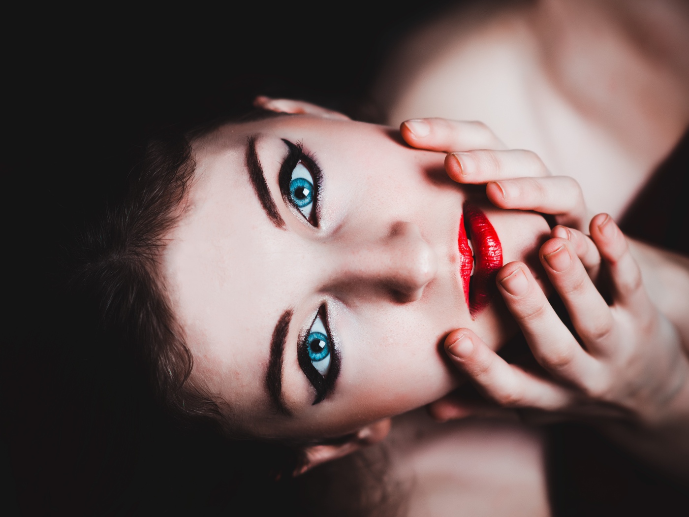Красивая голубоглазая девушка с красными губами смотрит вверх 