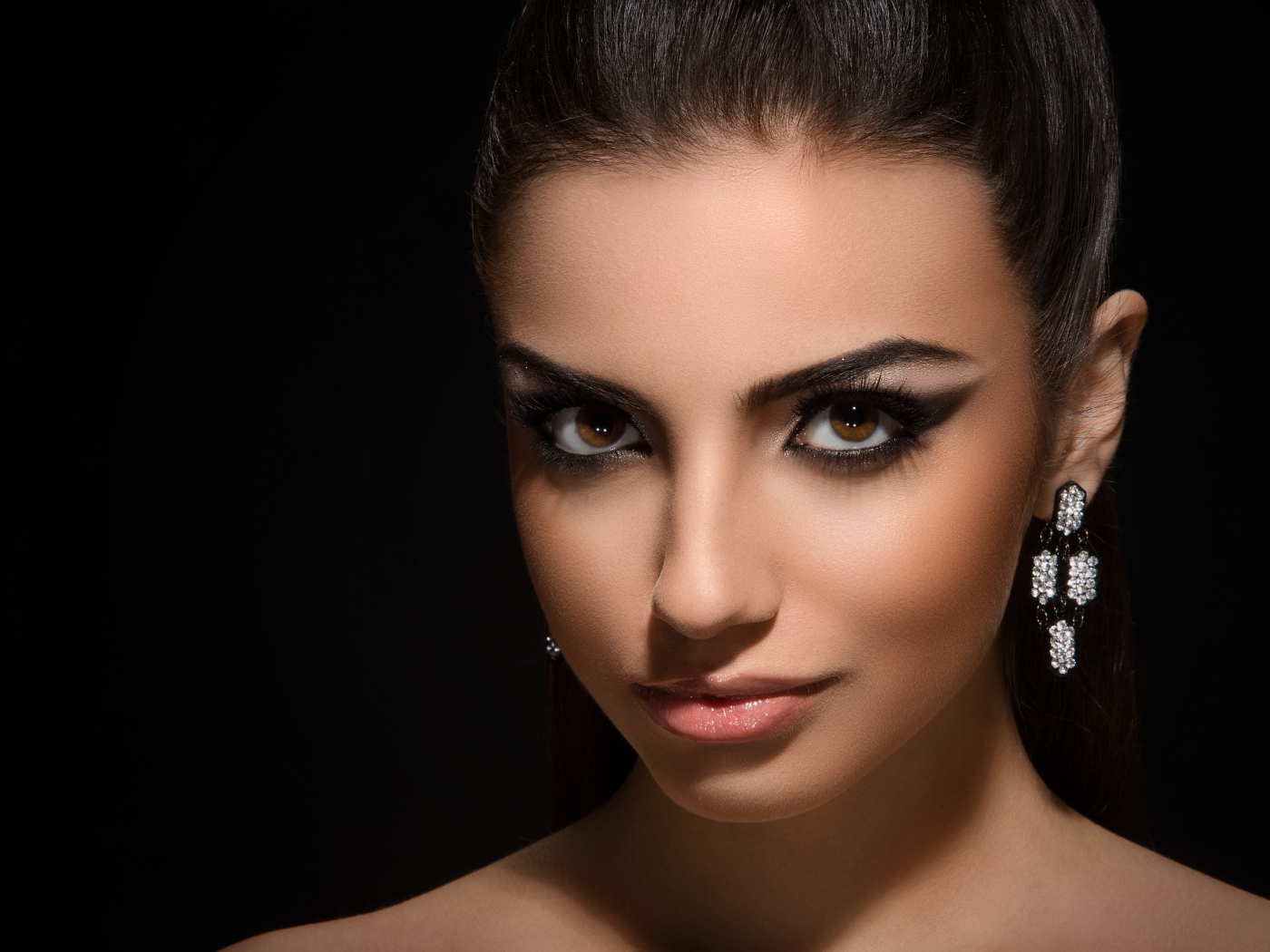 Красивая кареглазая девушка с прической на черном фоне