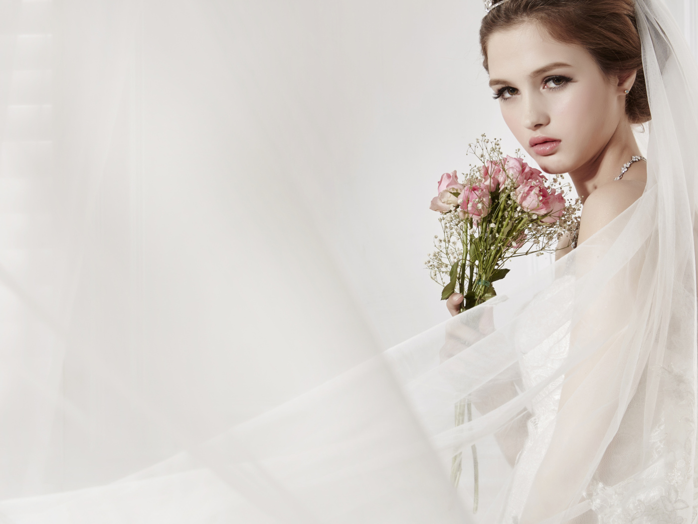 Красивая девушка невеста в свадебном платье с букетом роз 