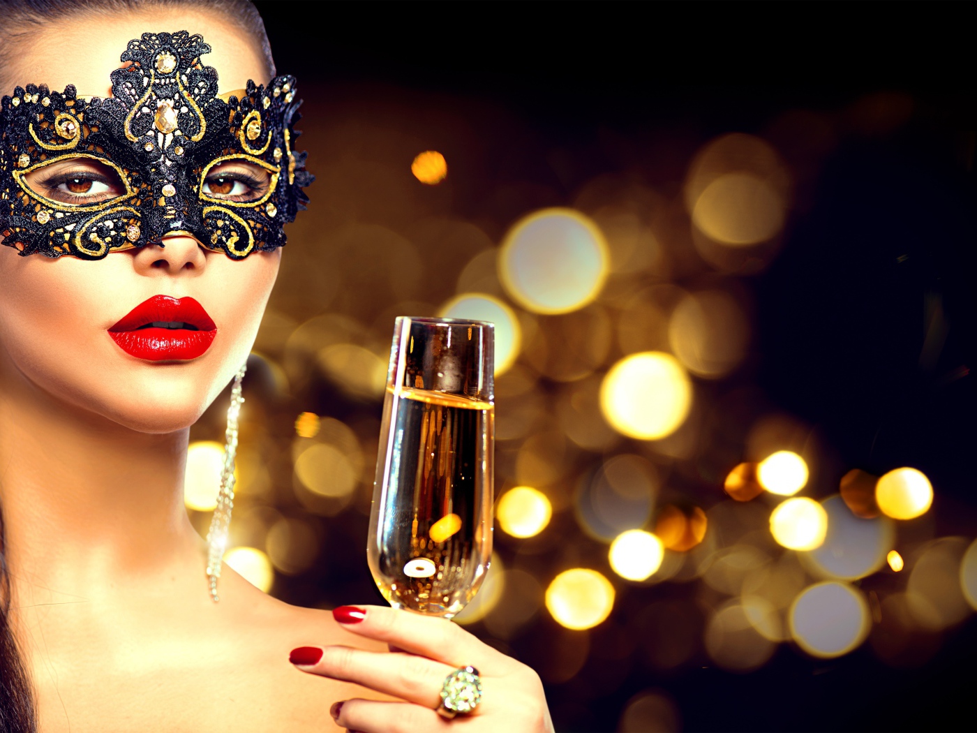 Красивая девушка в черной маске с бокалом шампанского