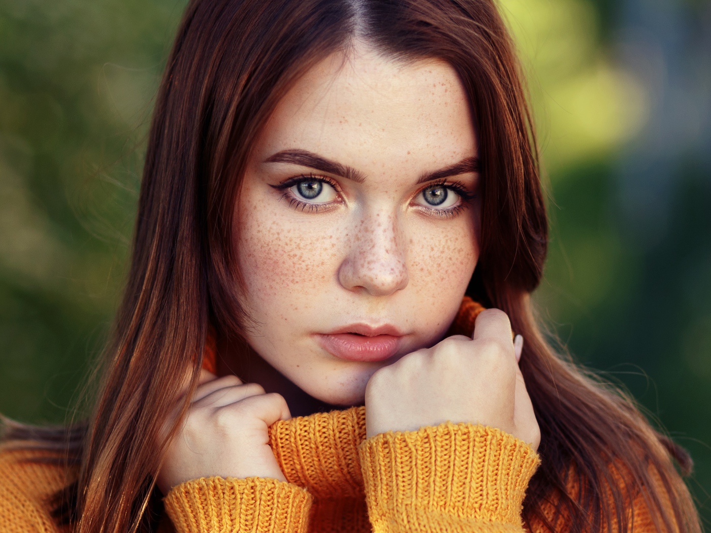 Красивая девушка в теплом свитере с веснушками на лице