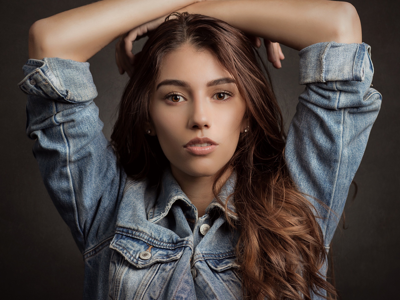 Красивая длинноволосая шатенка в джинсовой куртке 