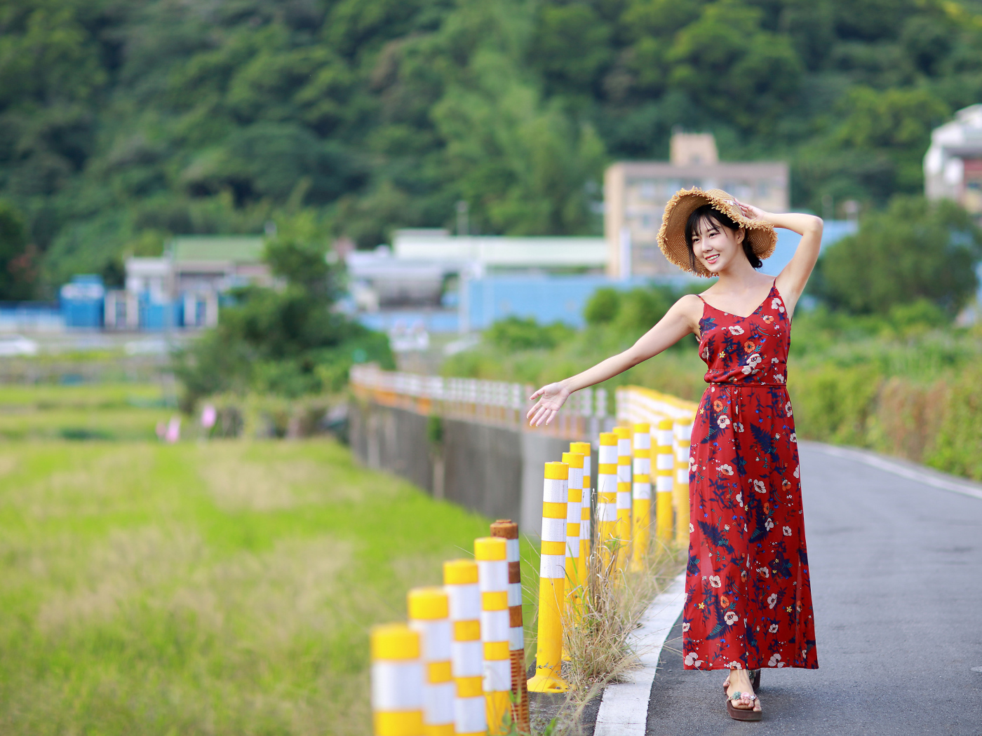 Веселая девушка азиатка в цветастом сарафане 