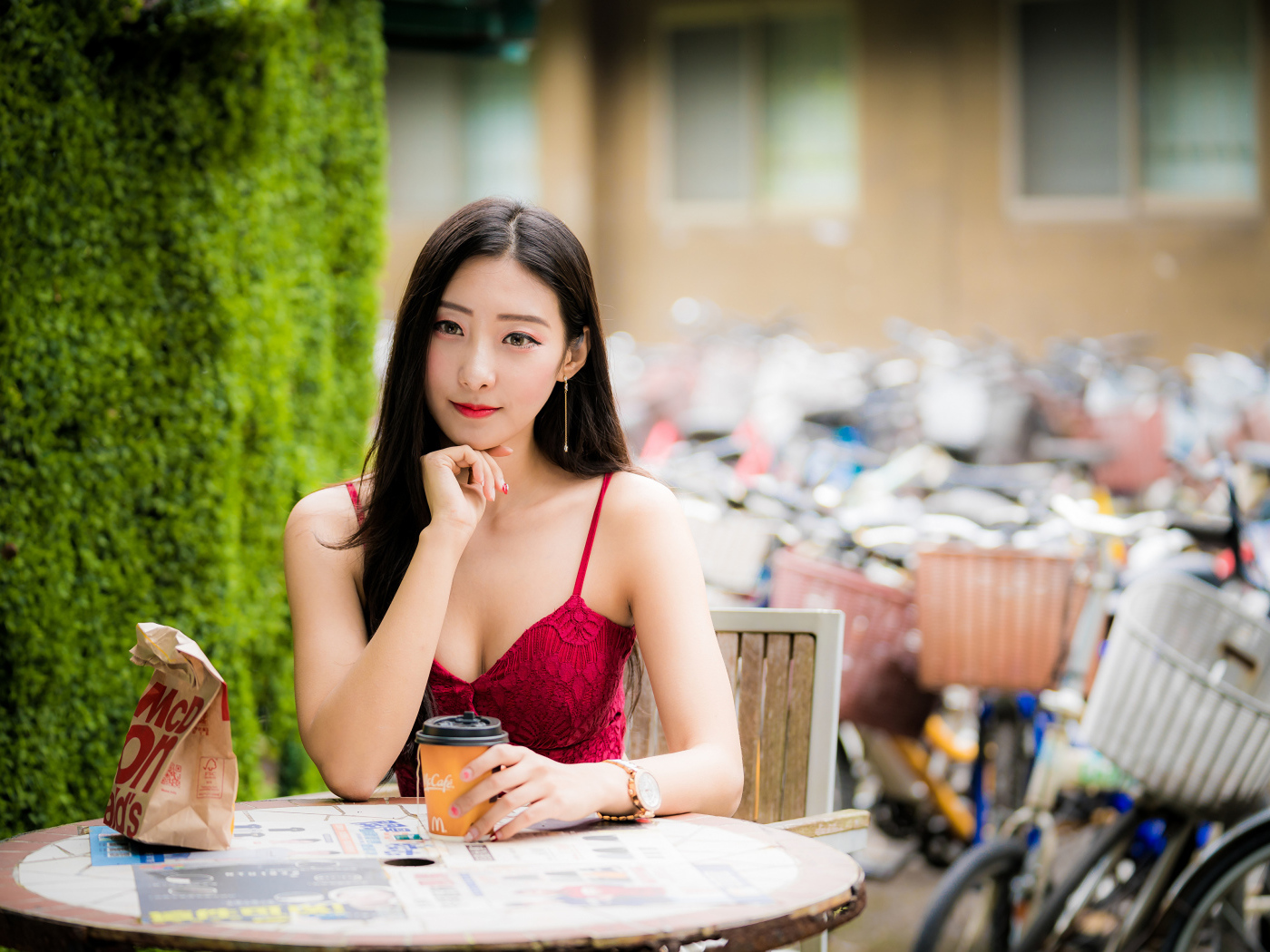 Милая девушка азиатка сидит за столиком в кафе