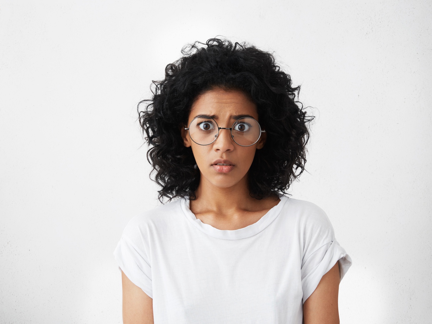 Темноволосая девушка в белой футболке на сером фоне