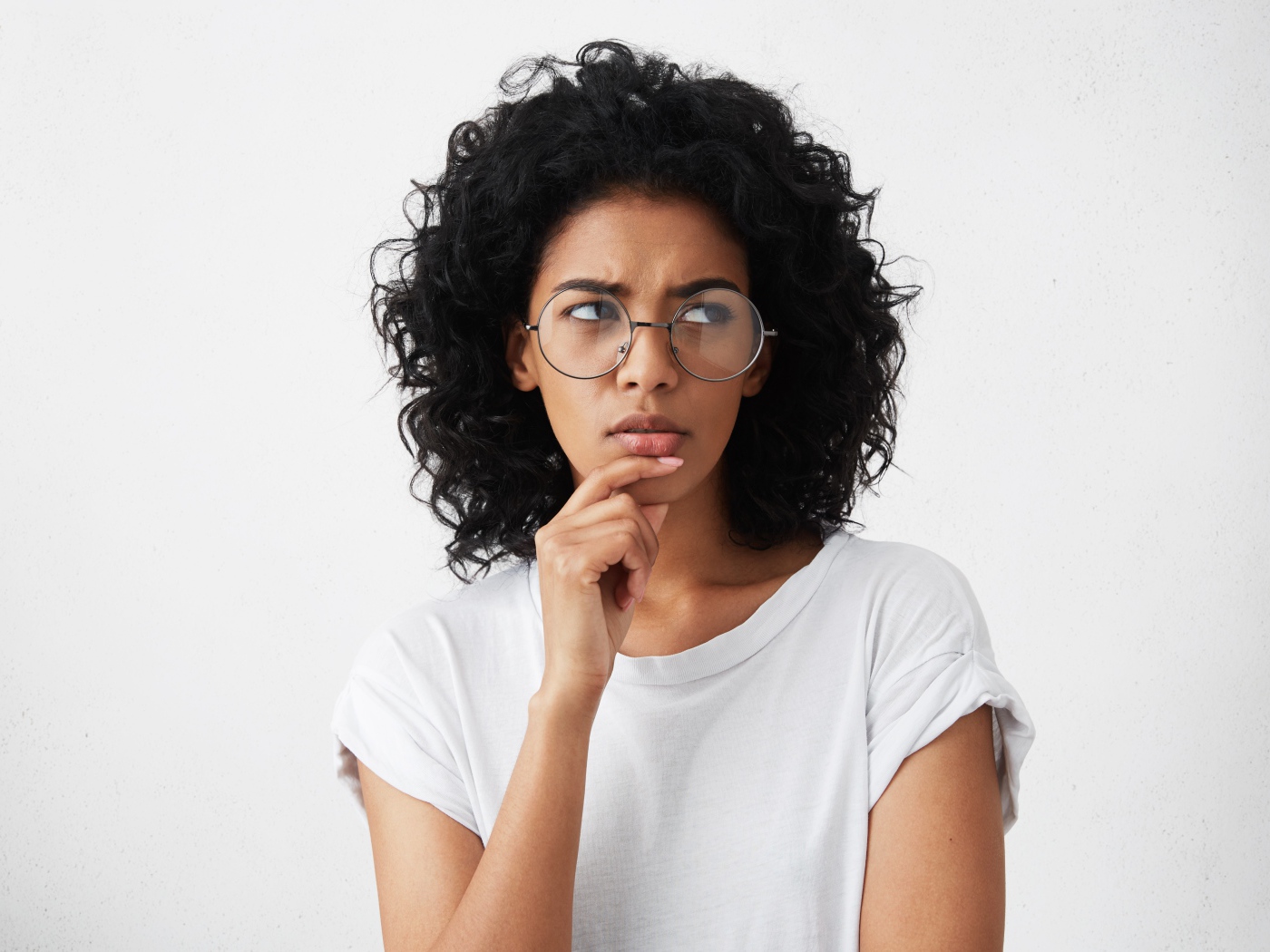 Темноволосая девушка в очках на сером фоне
