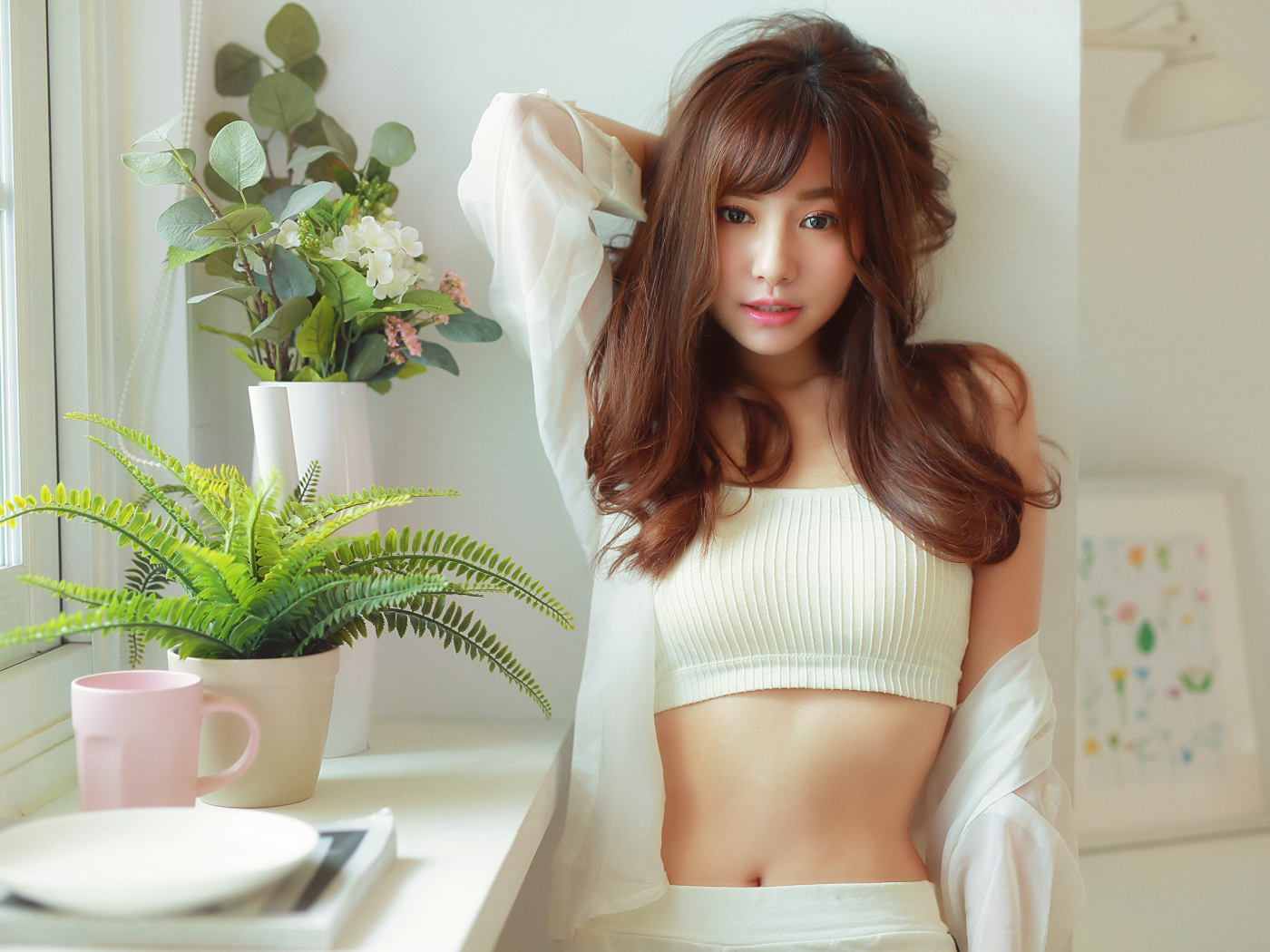 Нежная девушка азиатка стоит у окна