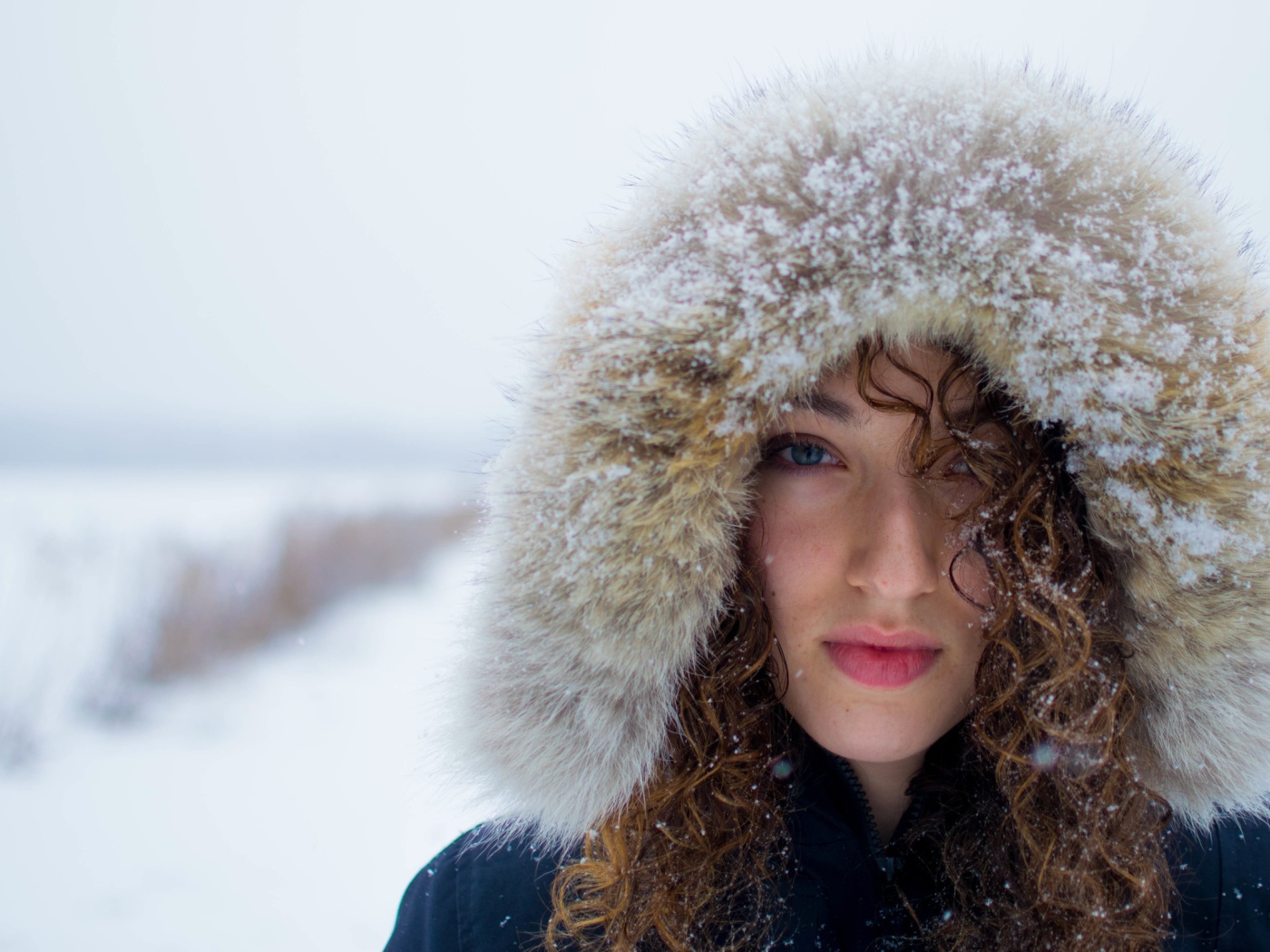 Девушка в заснеженном капюшоне на улице