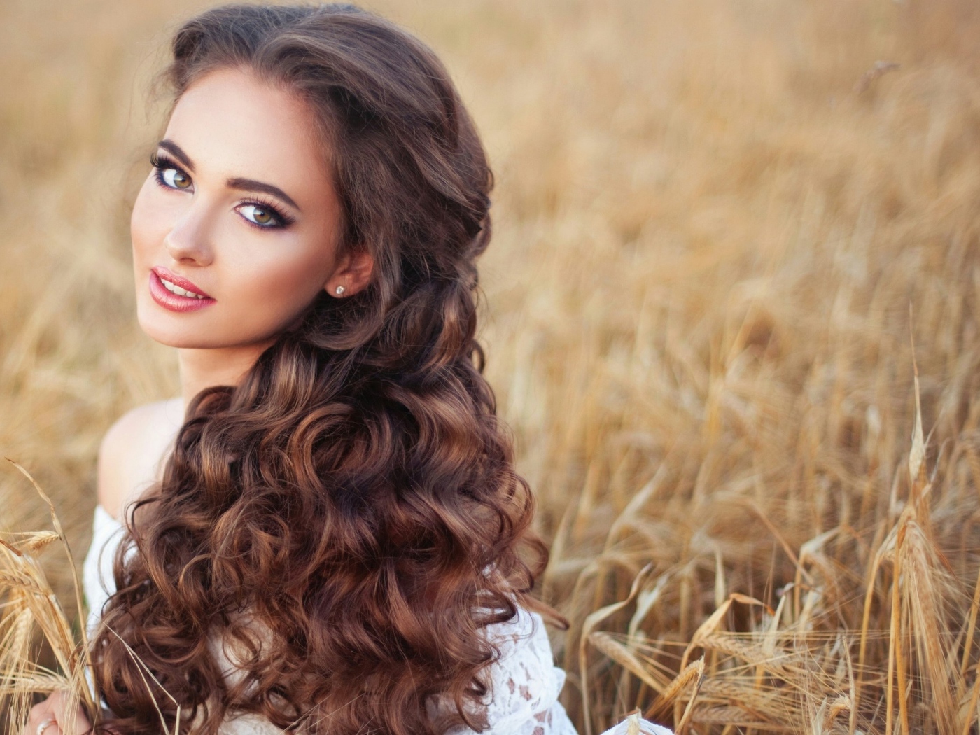 Девушка с красивыми длинными волосами на поле с пшеницей