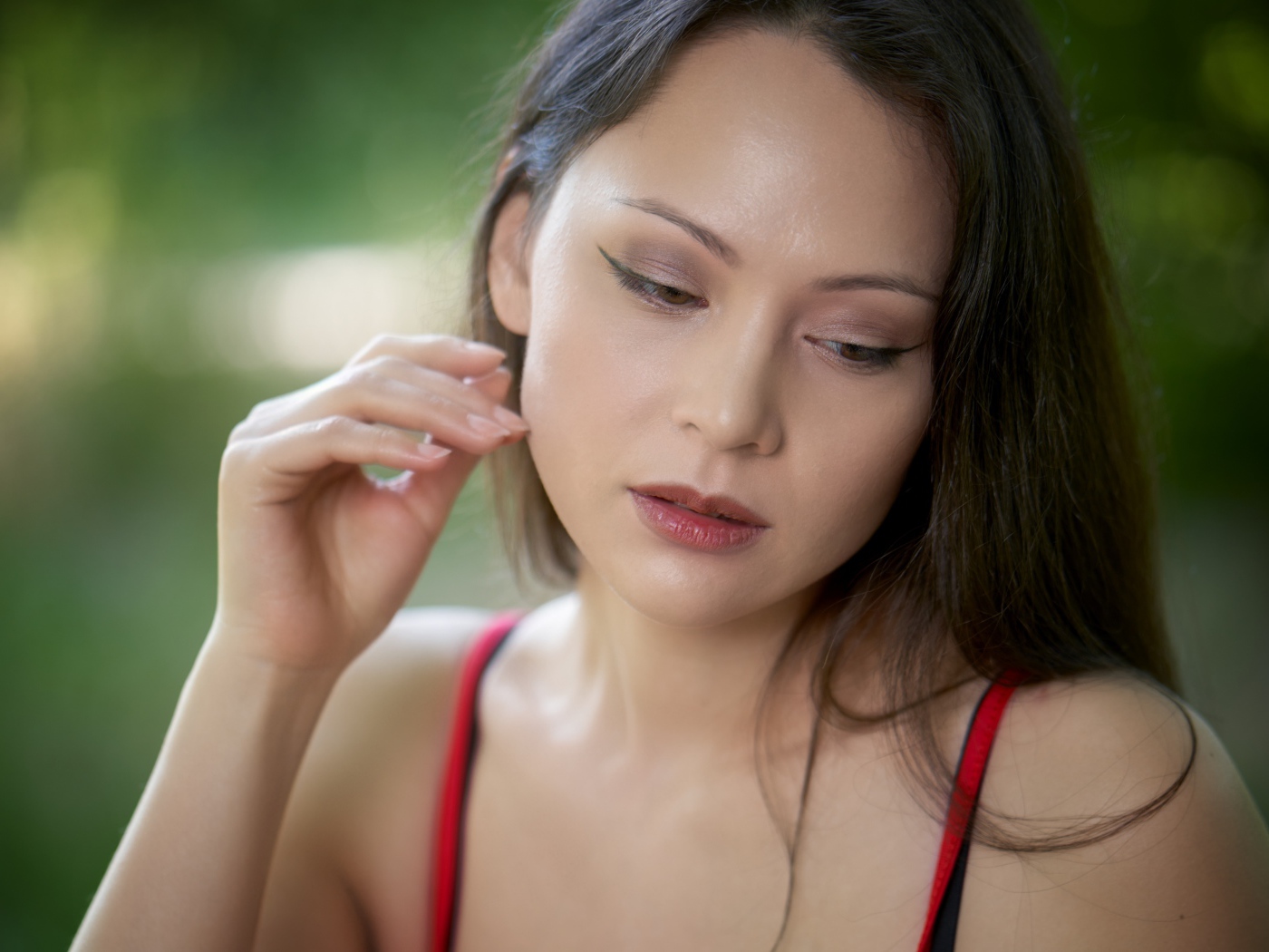 Девушка с опущенными глазами с рукой у лица