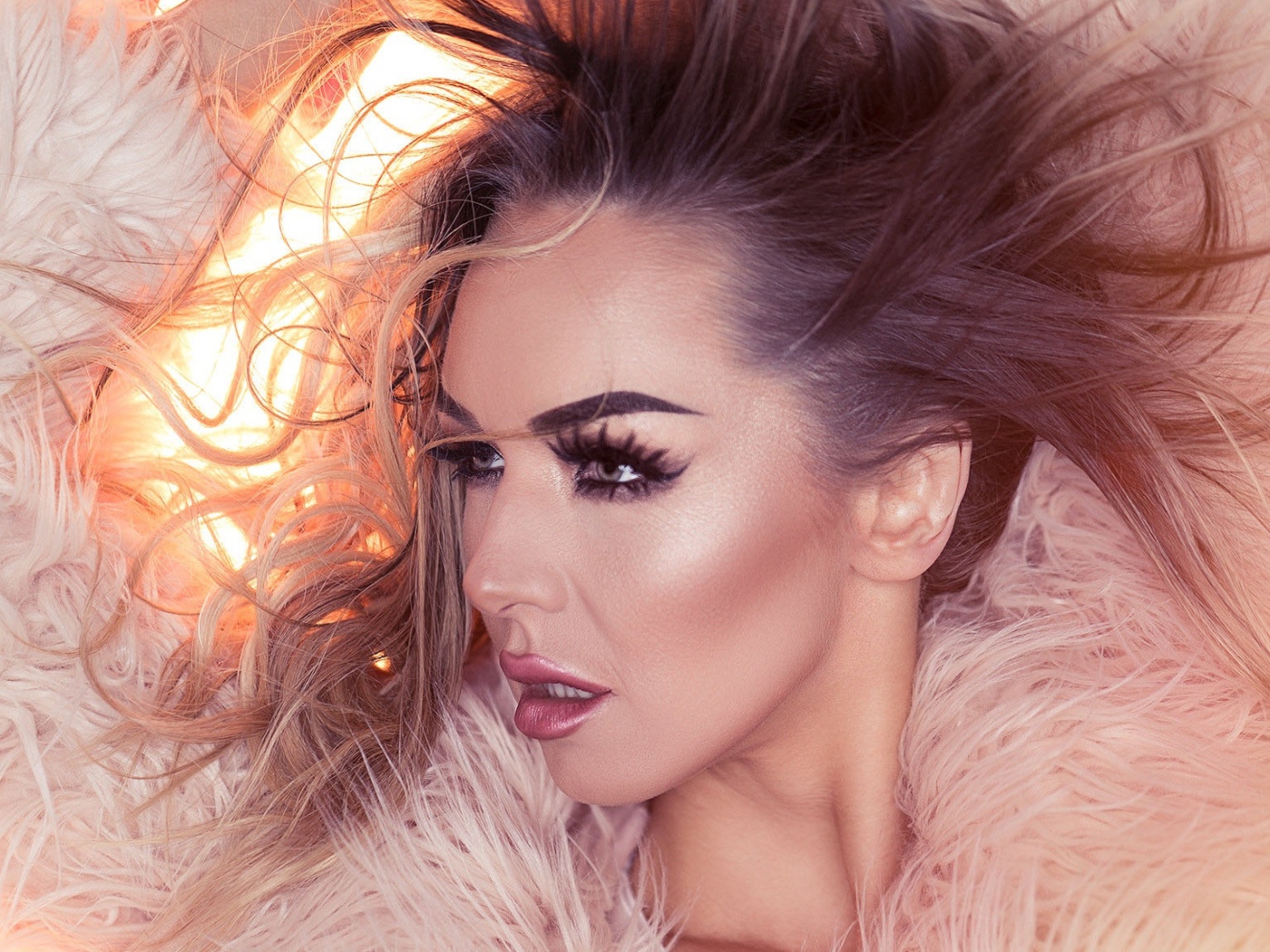 Девушка с распущенными волосами в розовой шубе 