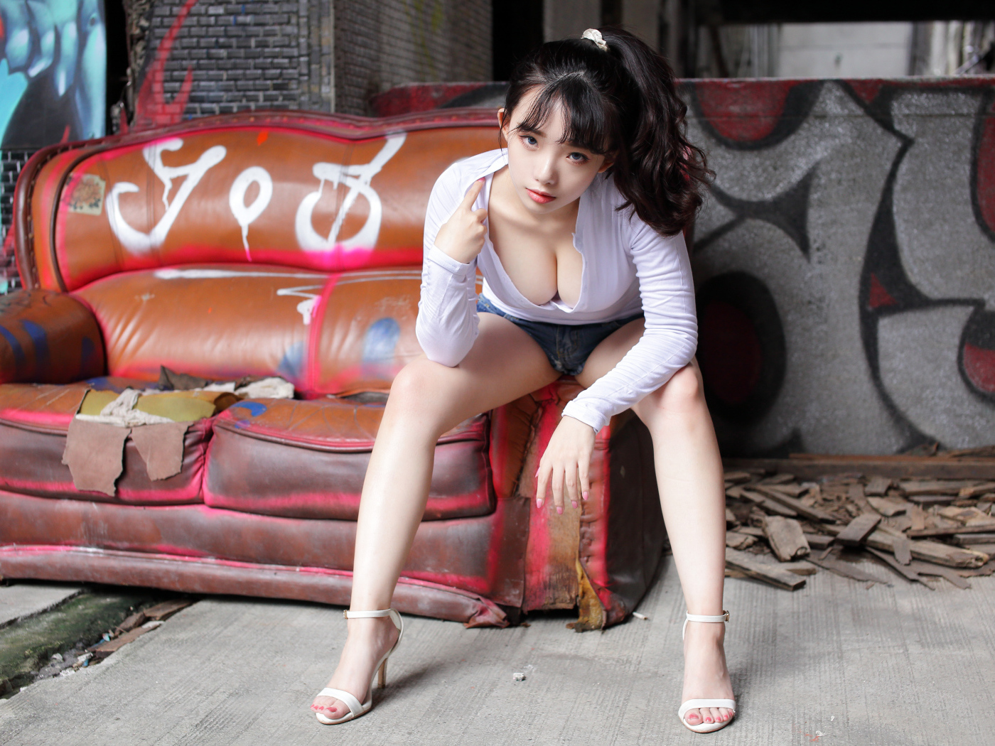 Длинноволосая девушка азиатка сидит на старом диване