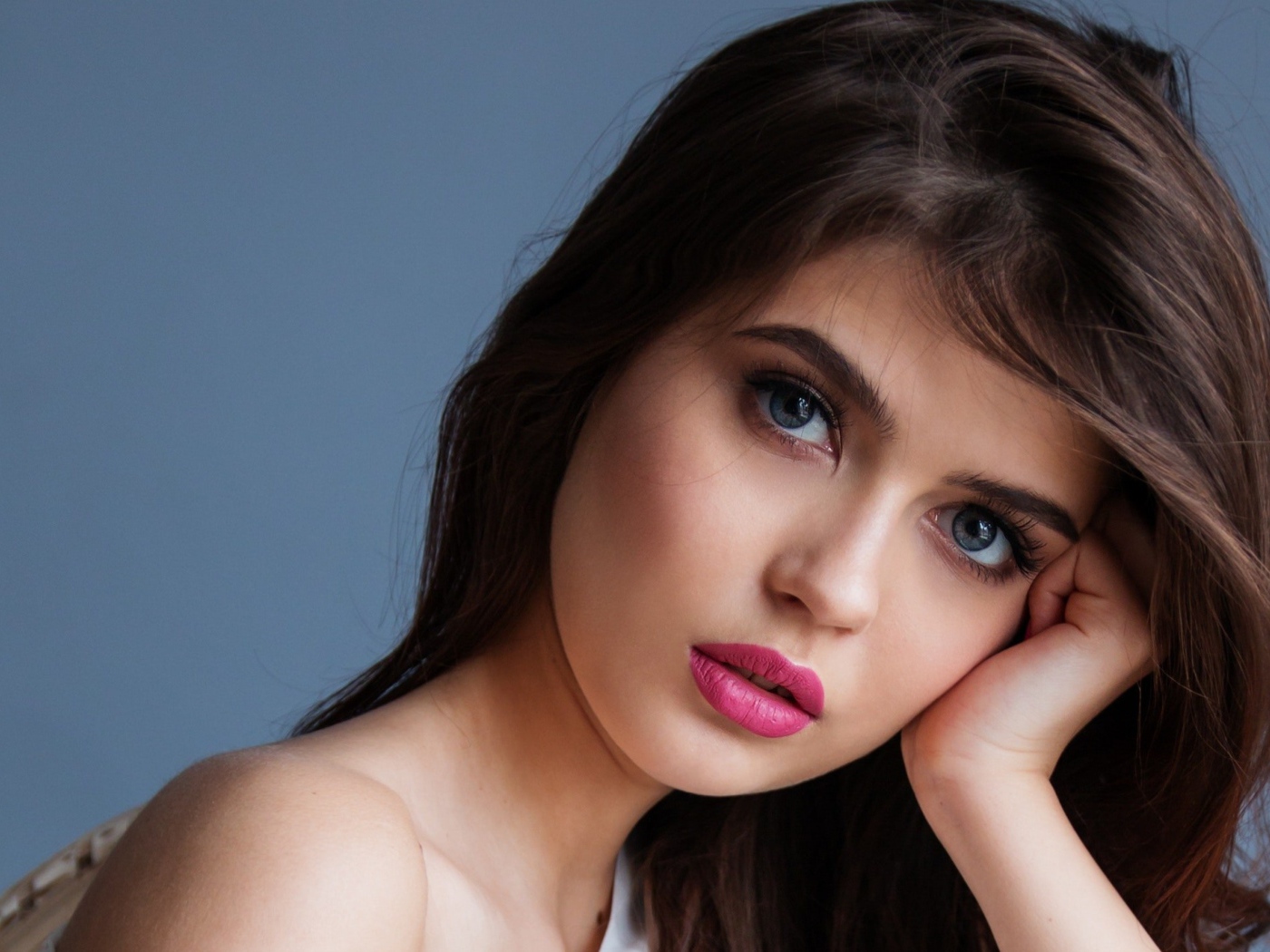 Милая девушка с розовыми губами на сером фоне