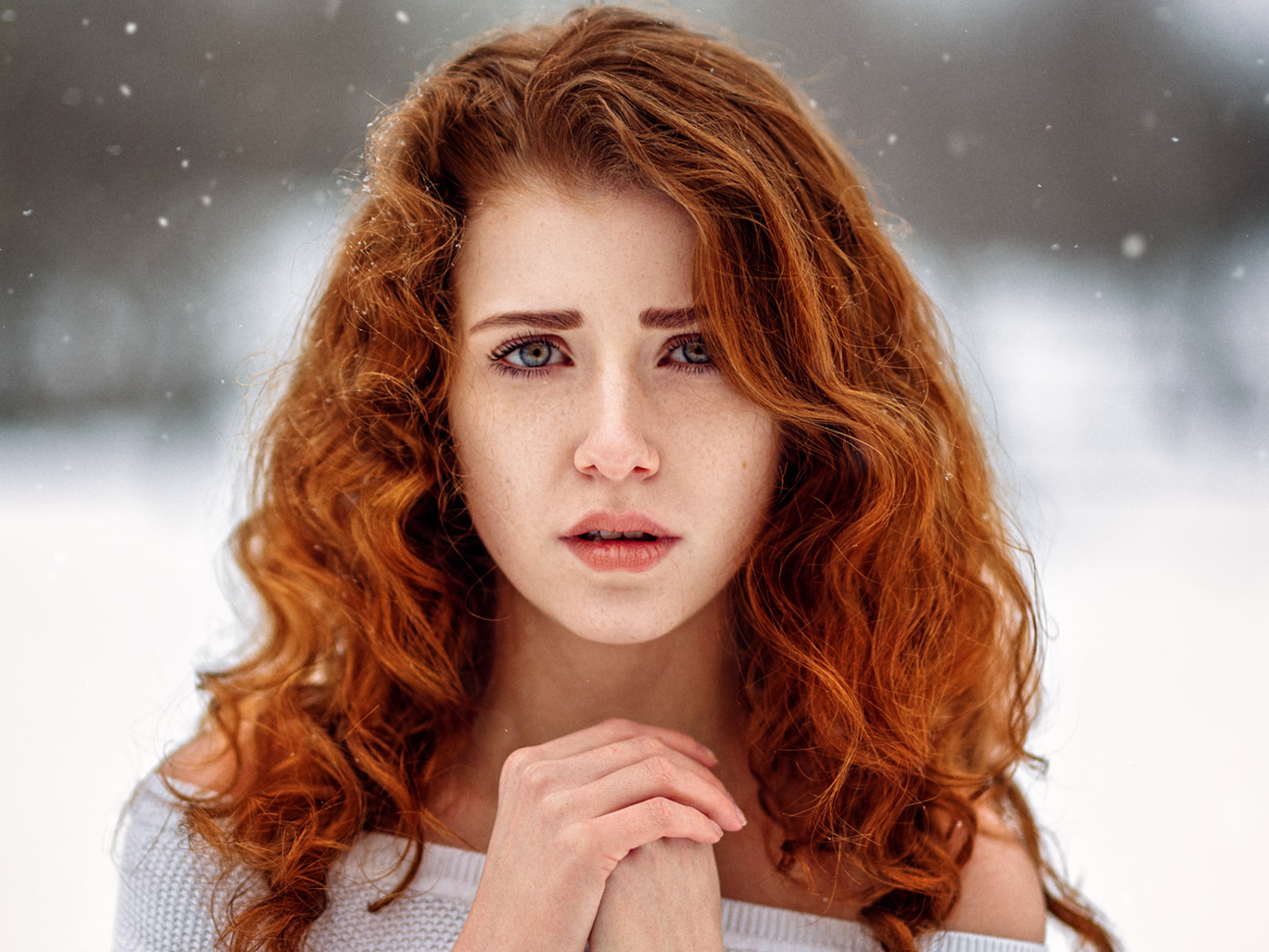 Рыжеволосая девушка замерзает на улице зимой