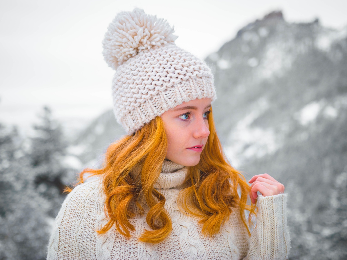 Рыжеволосая девушка в теплой шапке зимой 