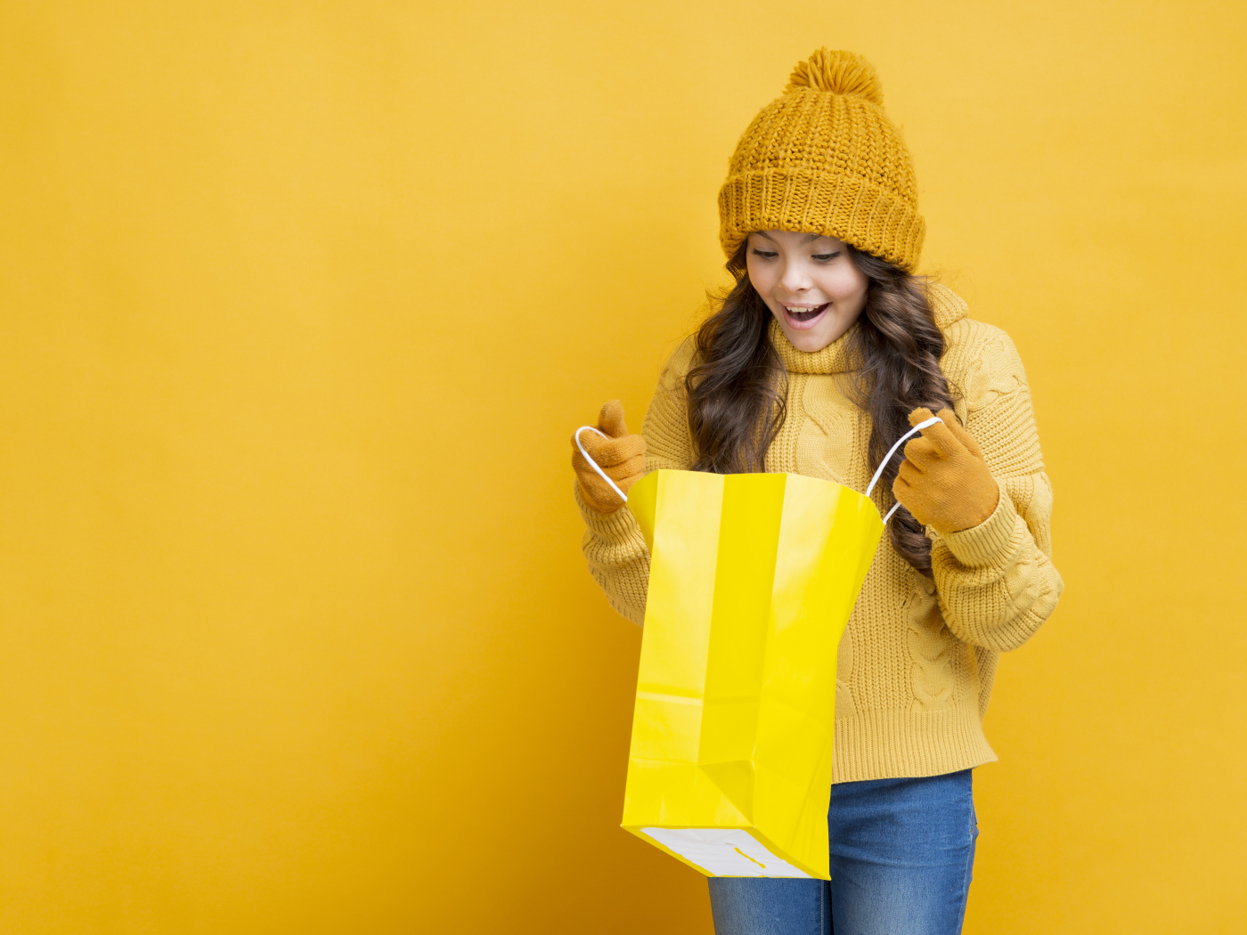 Улыбающаяся девушка в теплом свитере  с пакетом в руках 