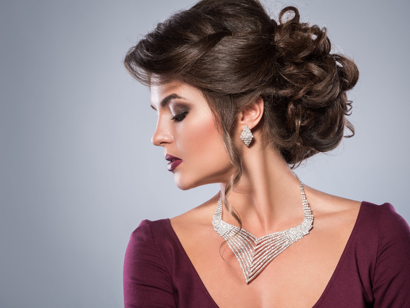 Стильная женщина с вечерней прической, макияжем и дорогими украшениями