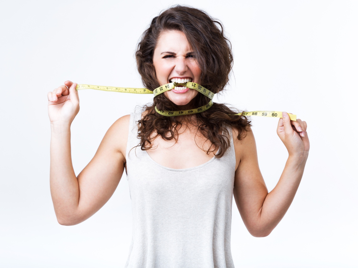 Блондинка в белой майке грызет сантиметр 