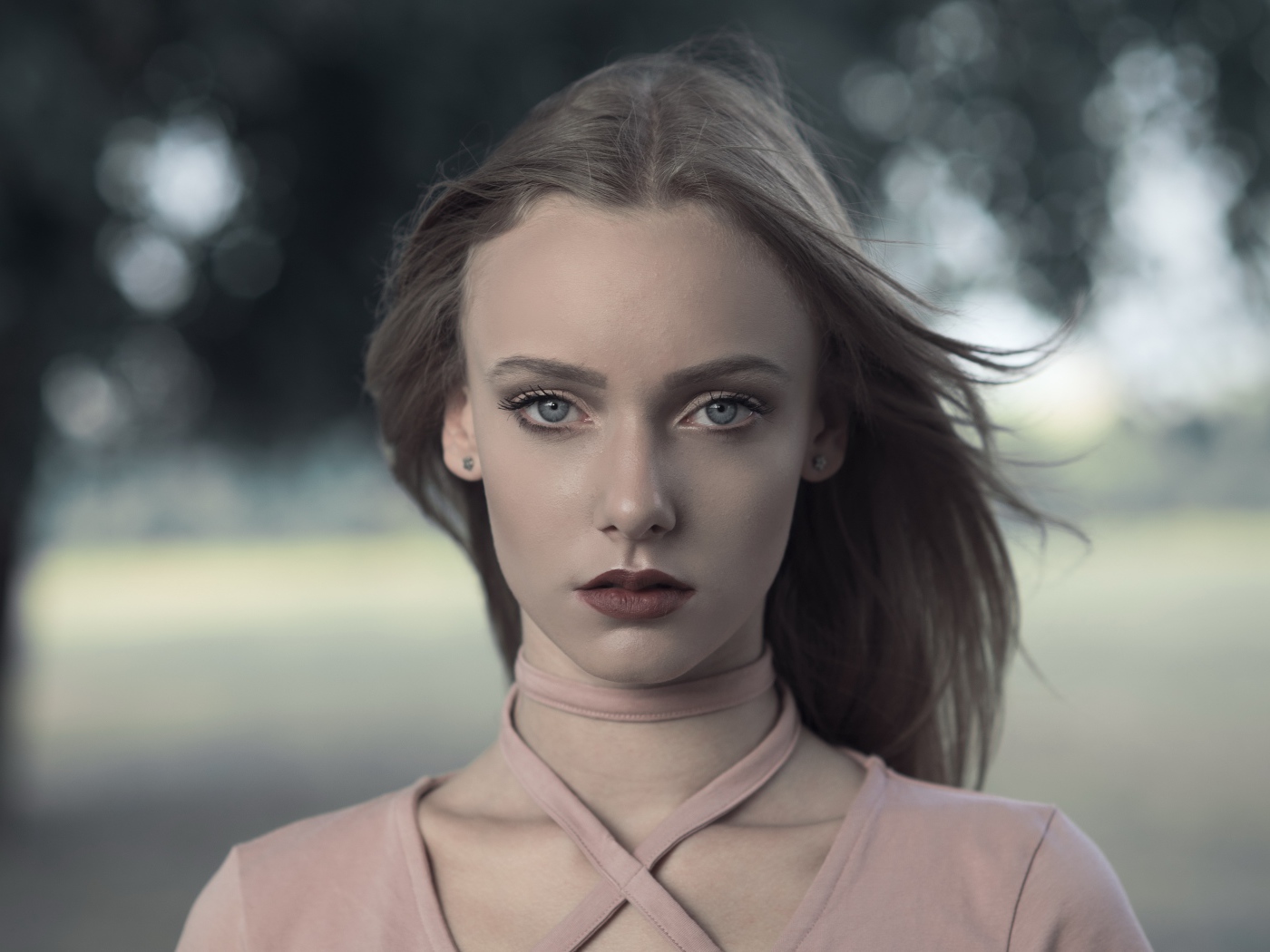 Ветер развивает волосы красивой голубоглазой девушки