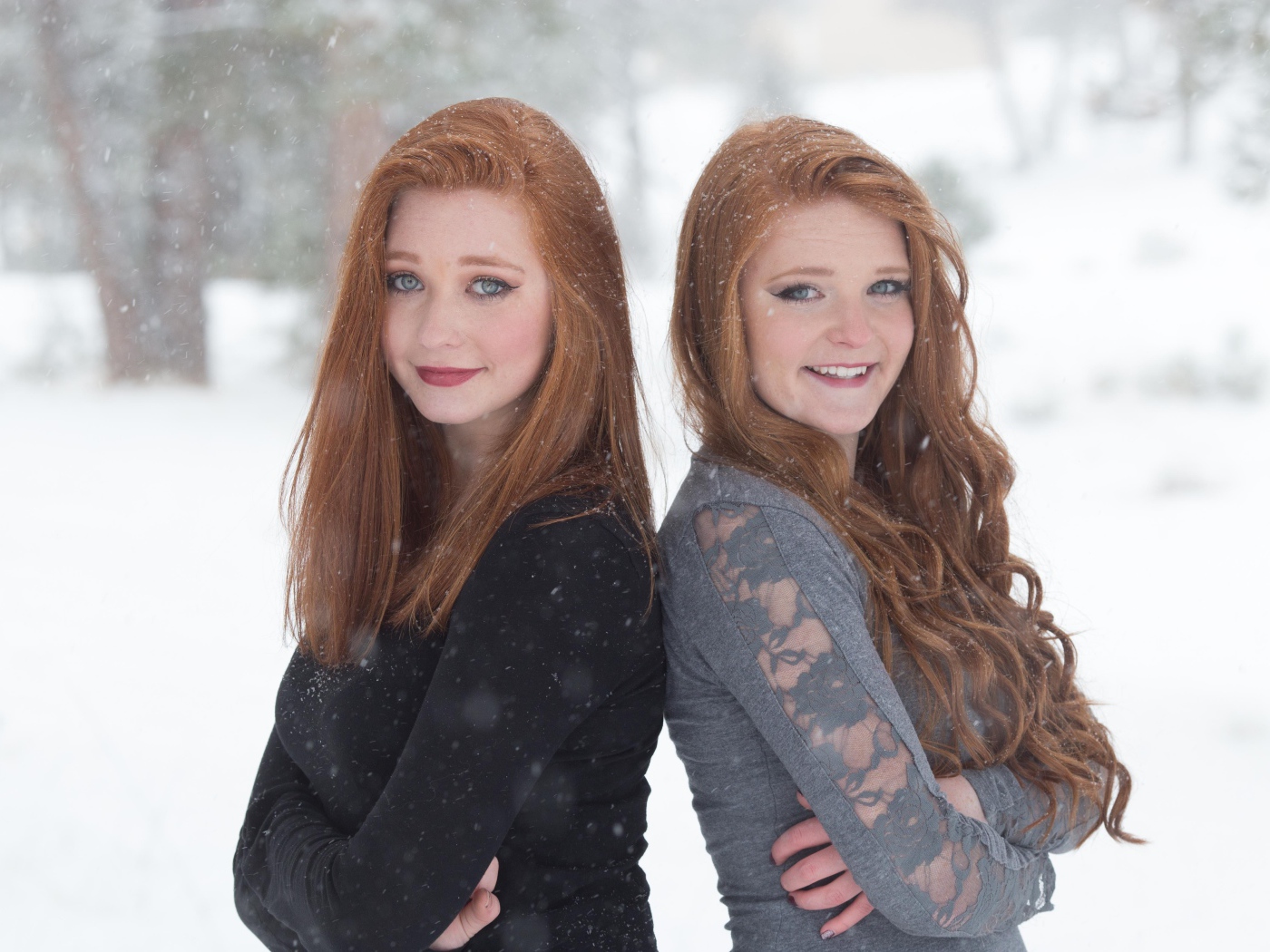 Две улыбающиеся рыжеволосые сестры на улице зимой 