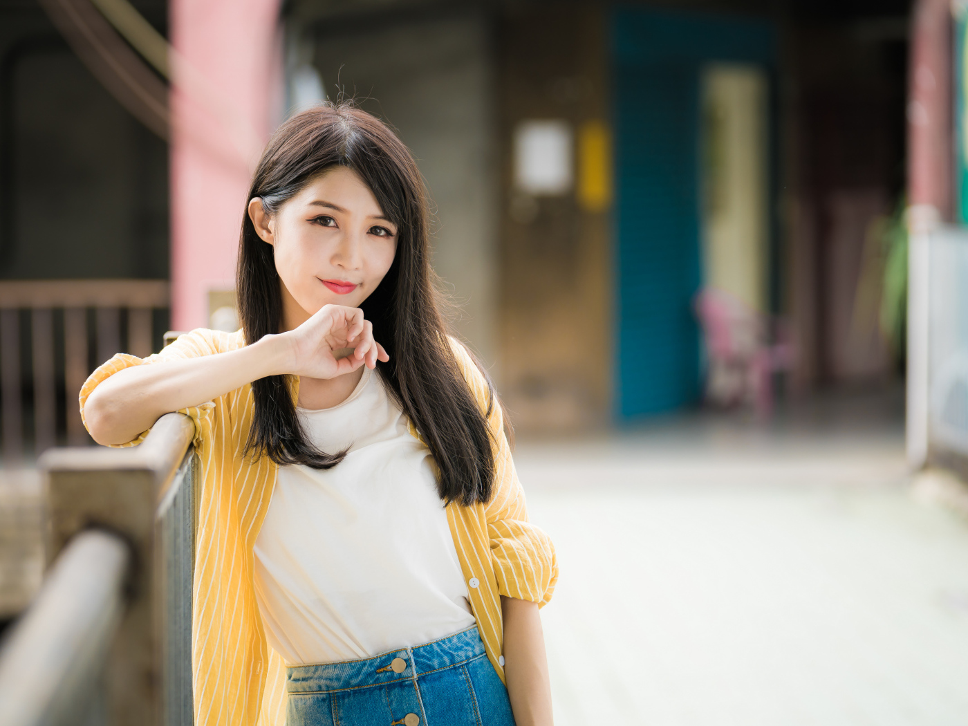 Молодая азиатка в белой майке и полосатой рубашке 