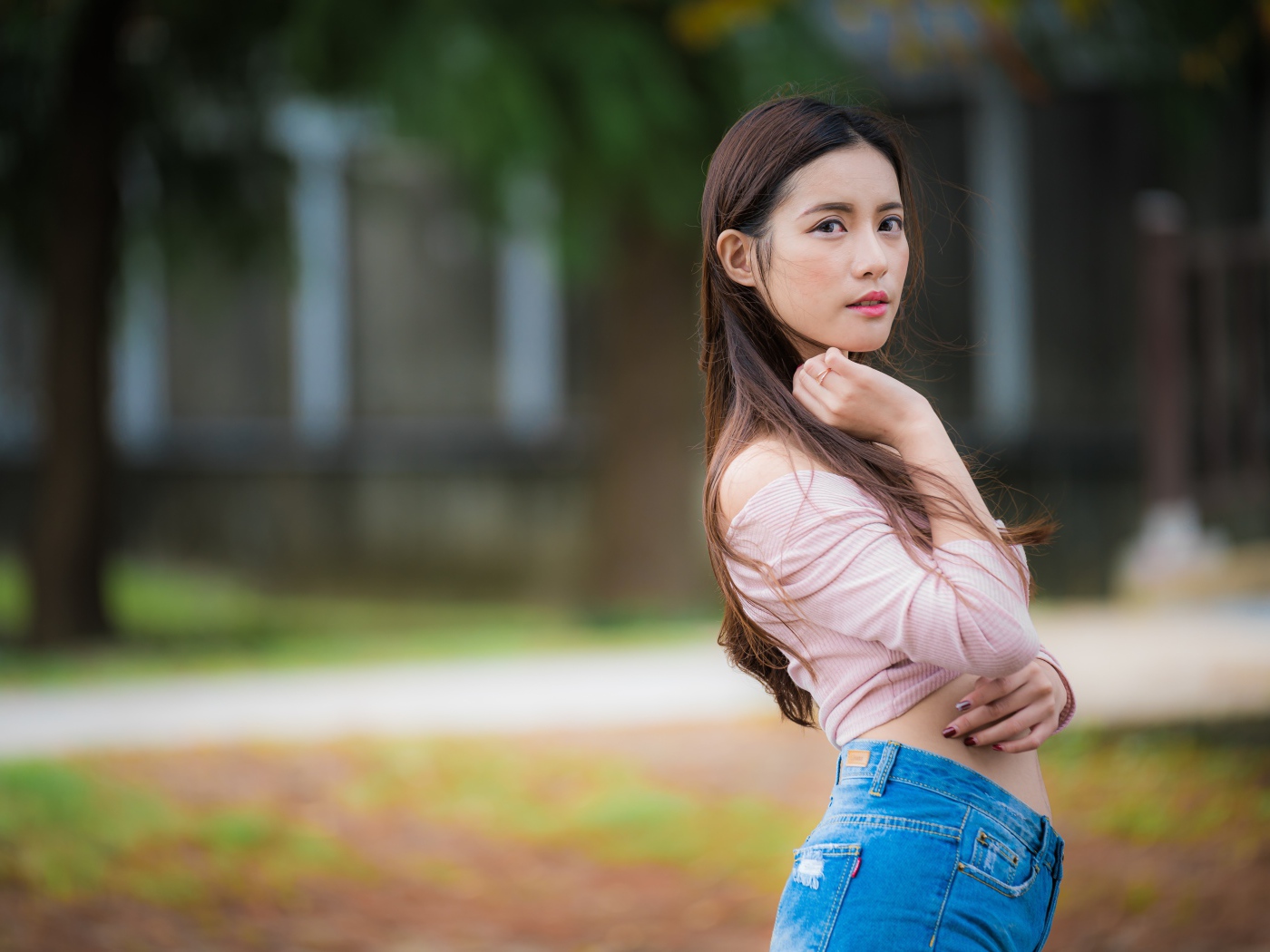 Молодая азиатка с длинными волосами в синих джинсах